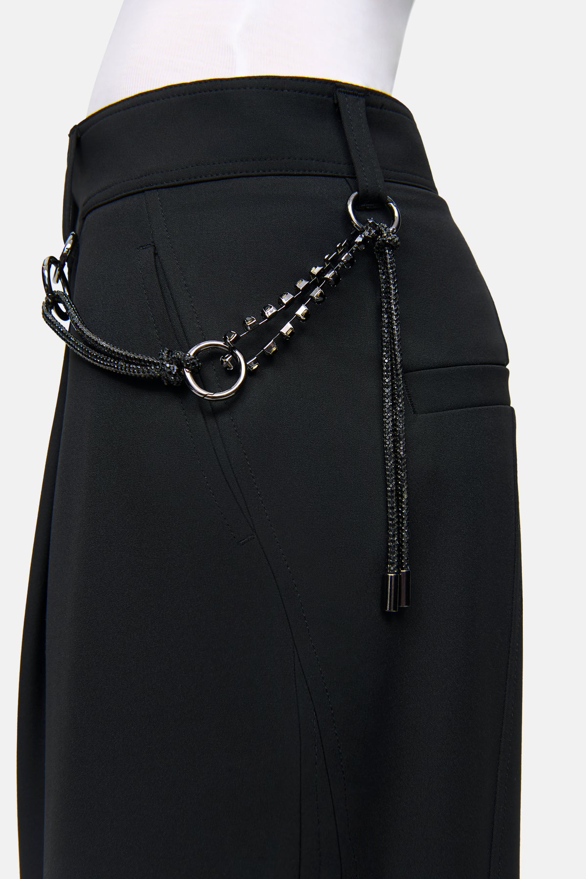 Schwarze O-Shape Hose aus 67% Polyester, 29% Viskose, 4% Elasthan mit Charivari-Kette, in seitlicher Ansicht.