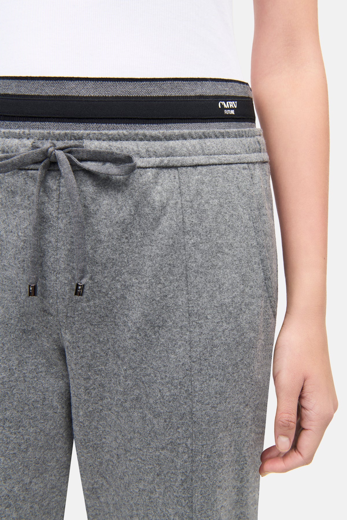 Graue O-Shape Hose aus Flanell-Jersey mit Stretchanteil, Doppelbund und Kordelzug. Person trägt sie im Innenbereich.