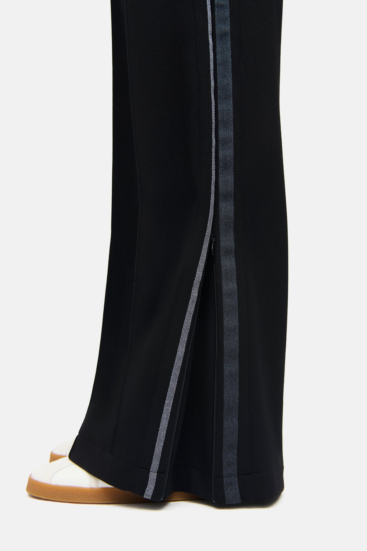 Schwarze Wide Leg Hose aus 47% Polyamid, 44% Viskose, 9% Elasthan mit seitlichen Galons in sportlichem Design.