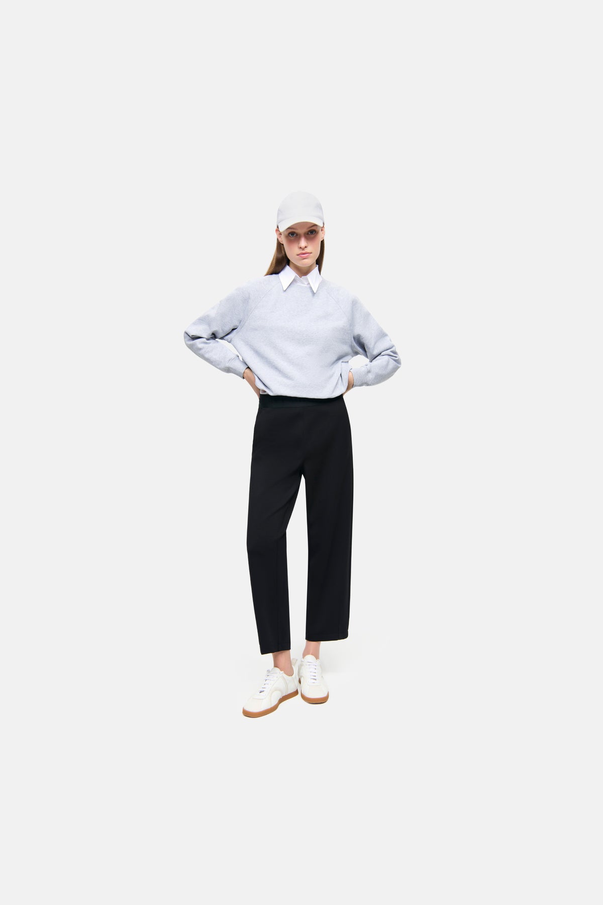 Schwarze Neoprenhose im O-Shape Design, verkürzte Länge, mit elastischem Bund und seitlichen Taschen, getragen von einer Person mit lässigem Outfit in einem urbanen Umfeld.