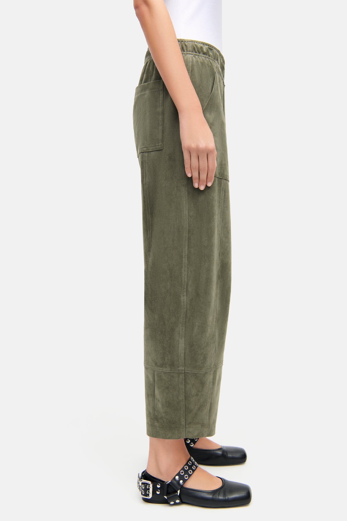 Grüne Hose im O-Shape aus veganem Velours, 92 % Polyester, 8 % Elasthan, mit aufgenähten Fronttaschen. Seitliche Ansicht.