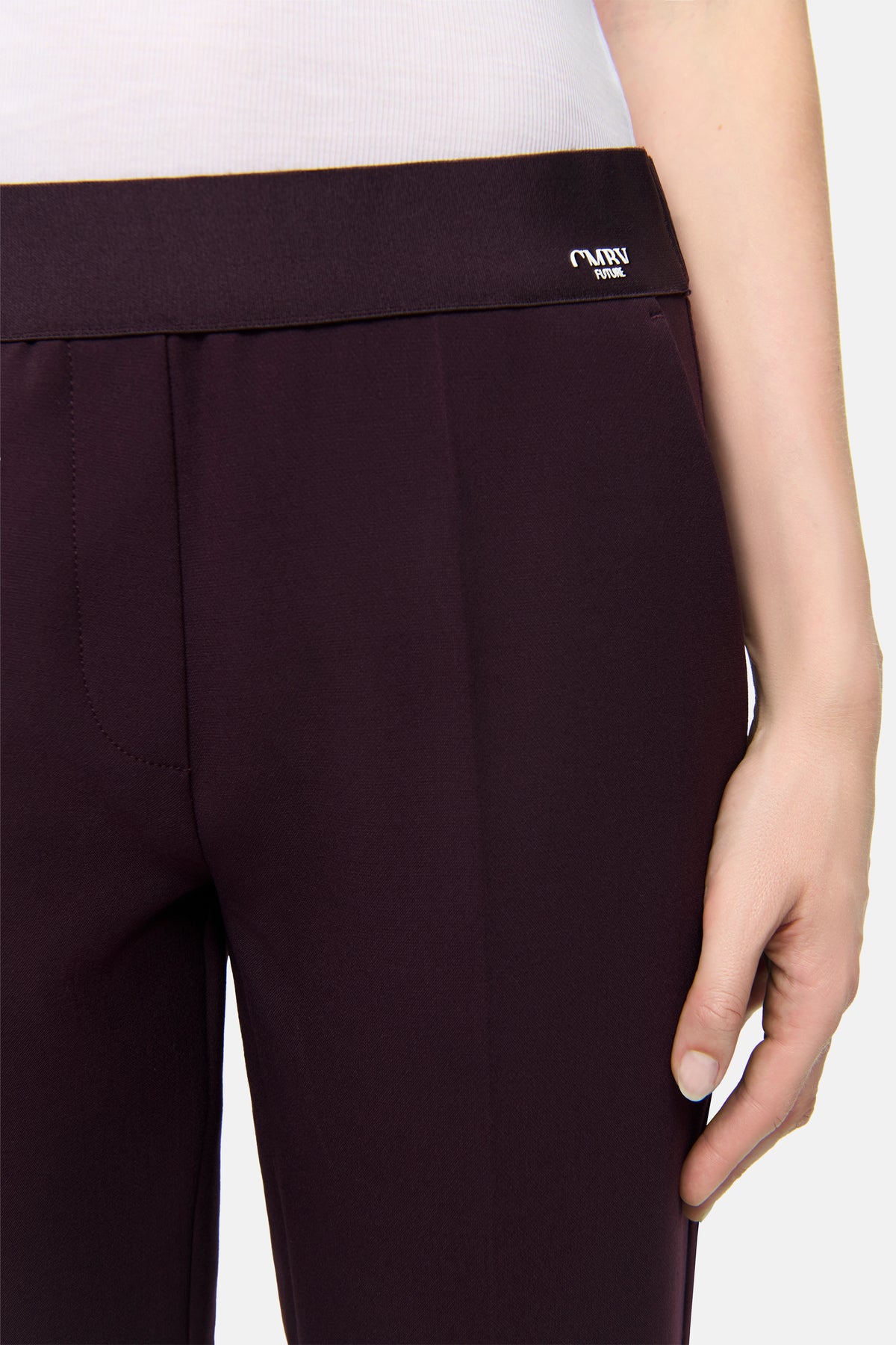 Bordeauxfarbene Hose in Karottenform aus Polyester, Viskose, Baumwolle und Elasthan, am oberen Teil einer Person getragen.