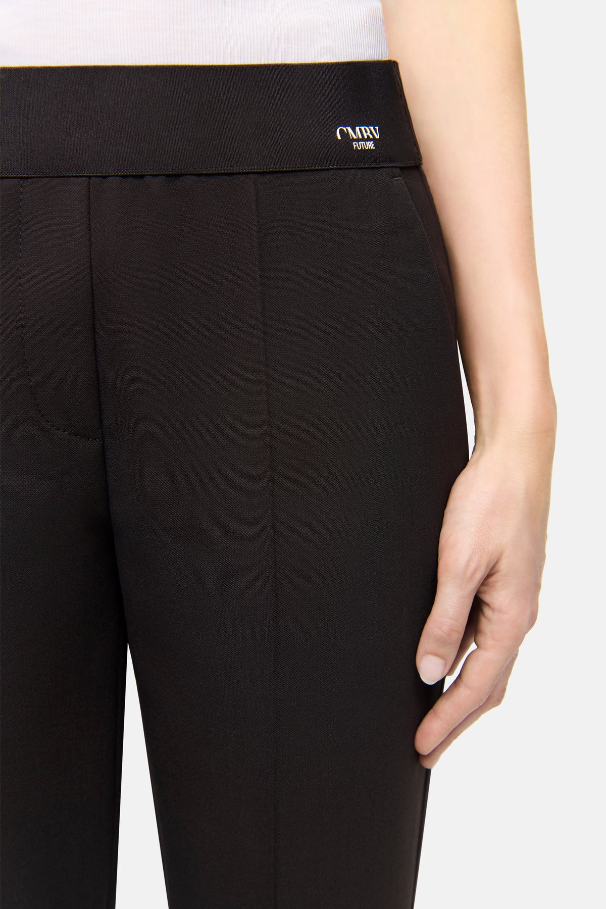 Dunkelbraune Hose aus 63% Polyester, 27% Viskose, 7% Baumwolle, 3% Elasthan. Seitliche Eingrifftaschen, getragen von Person.