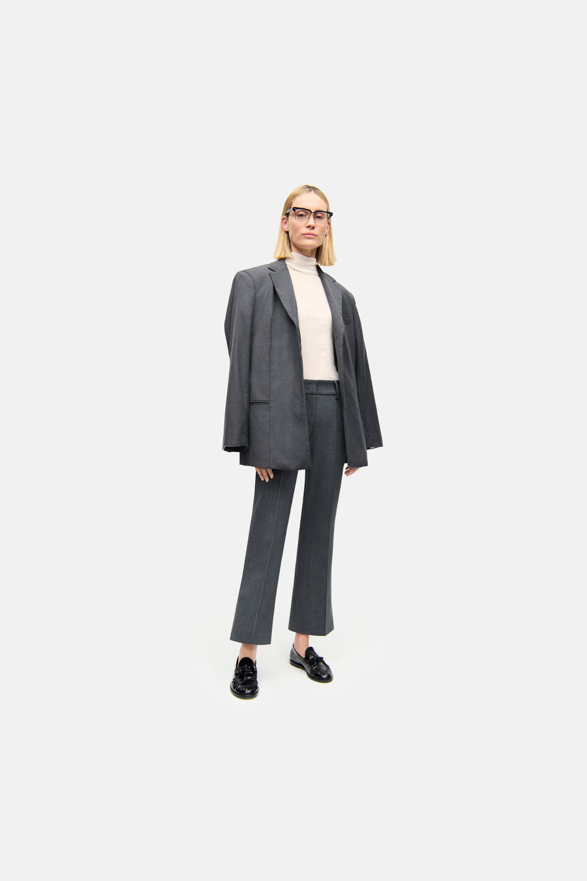 Graue Flared-Hose aus 63% Polyester, 27% Viskose, 7% Baumwolle, 3% Elasthan in einem geschäftlichen Umfeld getragen.