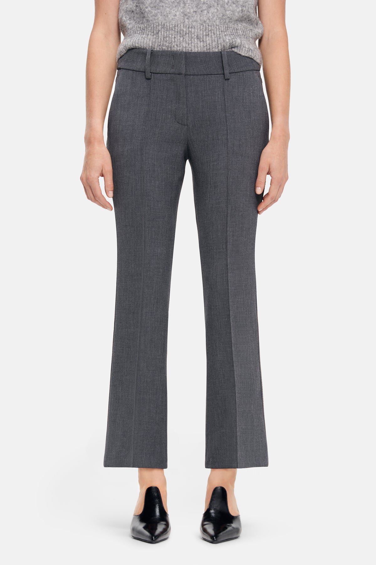 Graue Flared-Fit-Hose aus 63% Polyester, 27% Viskose, 7% Baumwolle und 3% Elasthan. Getragen in urbaner Umgebung.