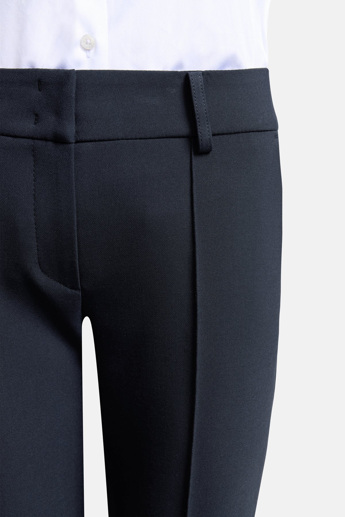 Dunkelblaue Flared-Hose aus Polyester, Viskose, Baumwolle und Elasthan. Getragen zu einem weißen Hemd.