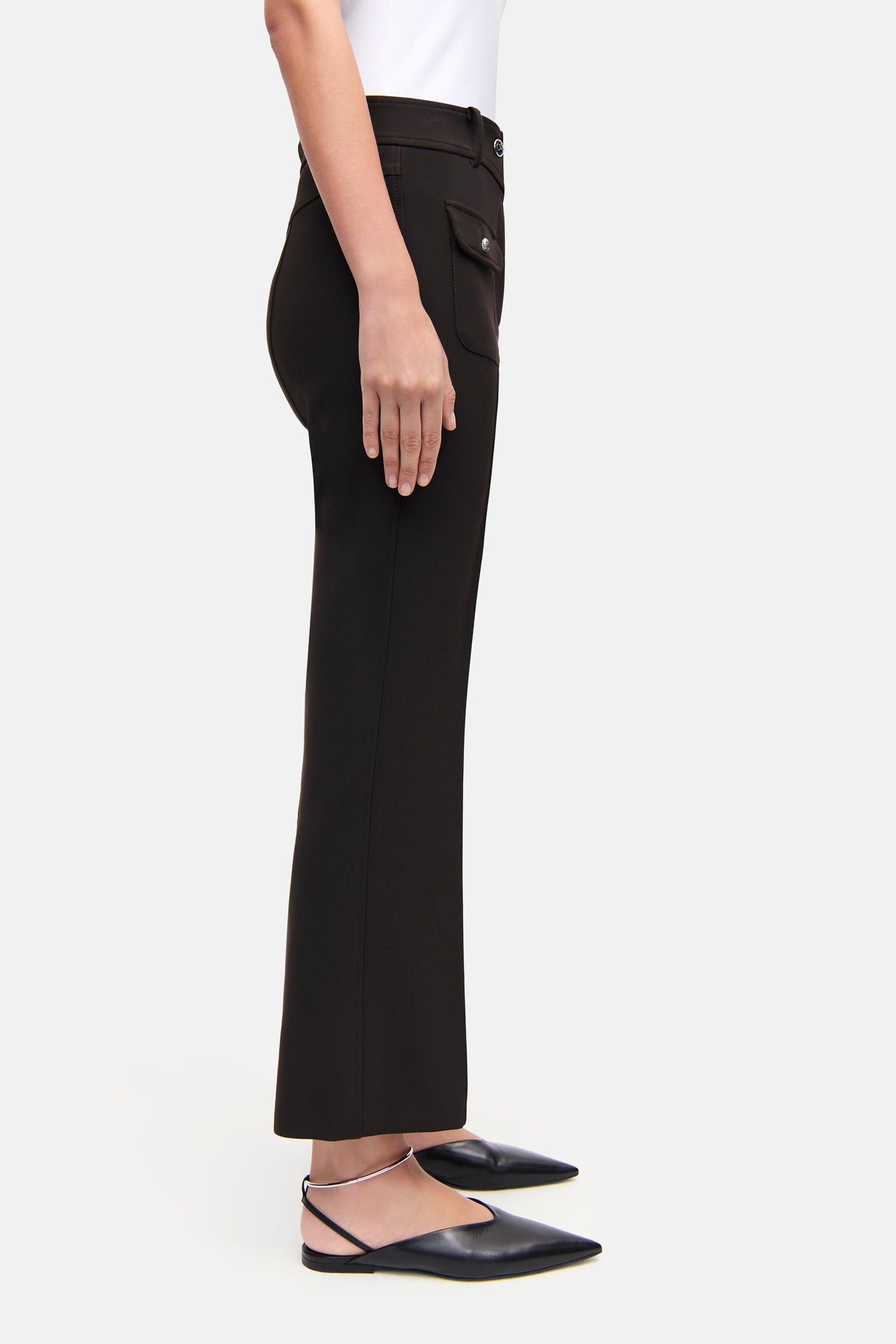 Flared Hose in dunklem Braun aus 7% Baumwolle, 63% Polyester, 3% Elasthan und 27% Viskose. Person in formeller Umgebung.