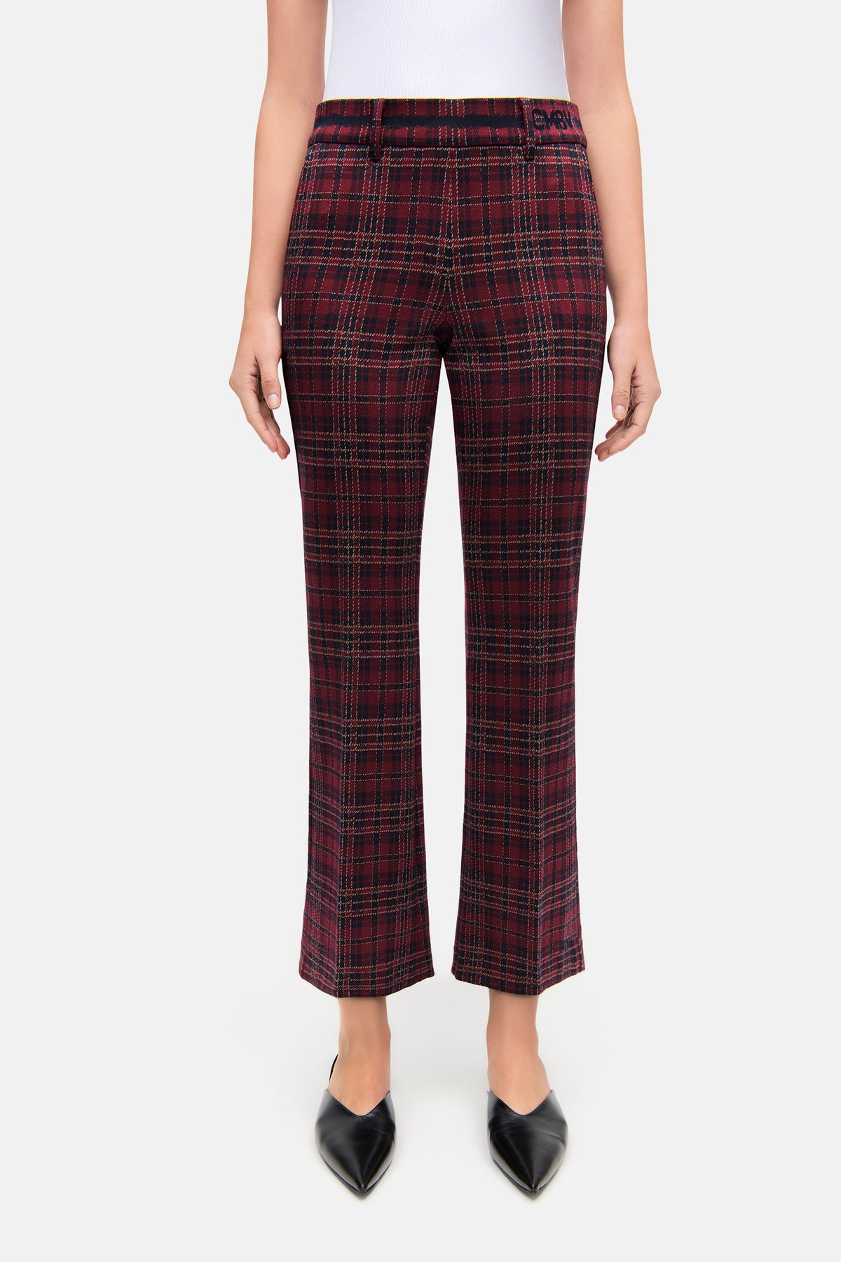 Damen in rot-karierter Hose im Tartan-Muster, aus 57 % Viskose, 39 % Polyamid, 4 % Elasthan, in urbanem Setting.