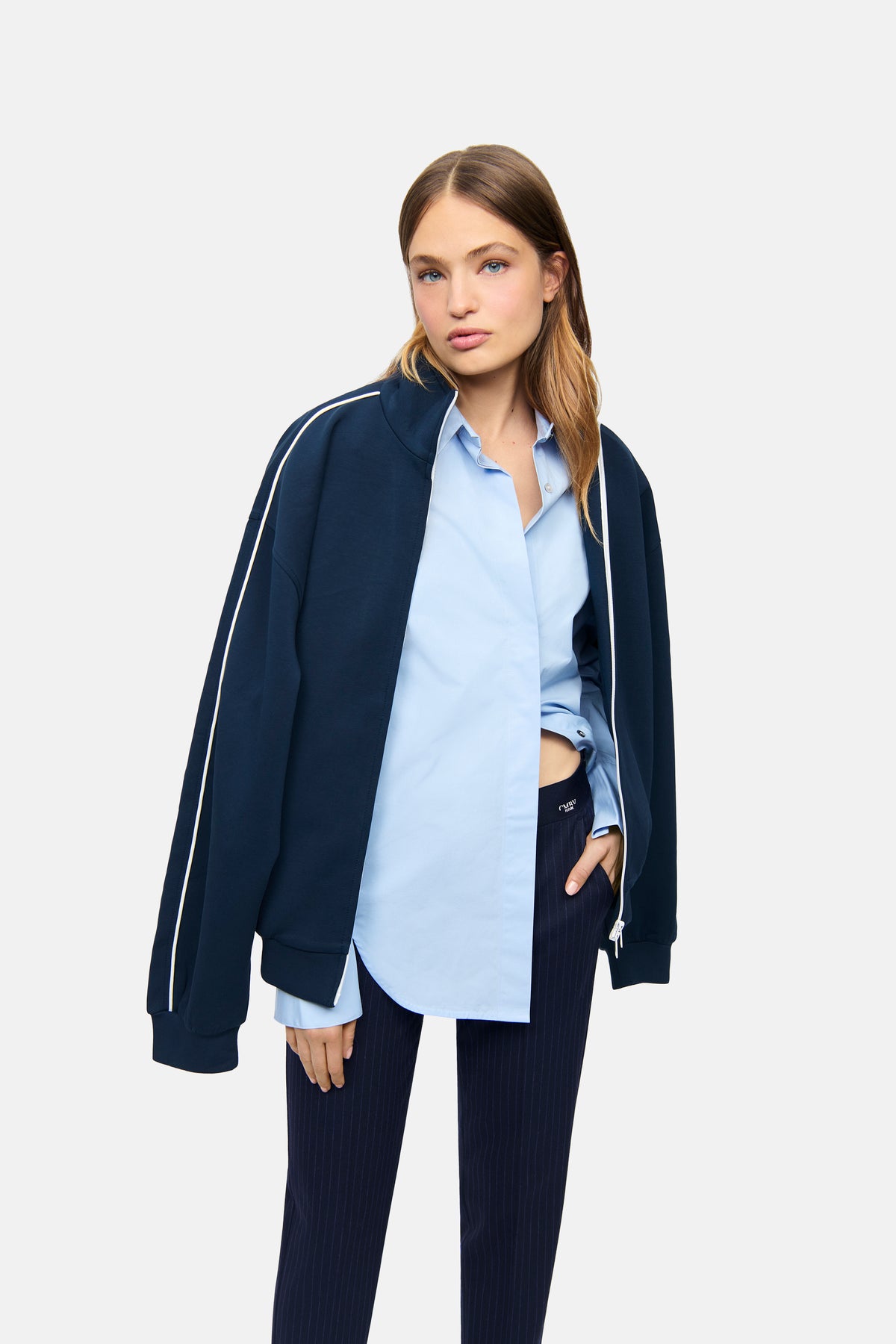 Dunkelblaue Nadelstreifenhose im Karottenstil aus Polyester, Viskose, Wolle und Elasthan-Mix, getragen in einem lässigen Outfit.