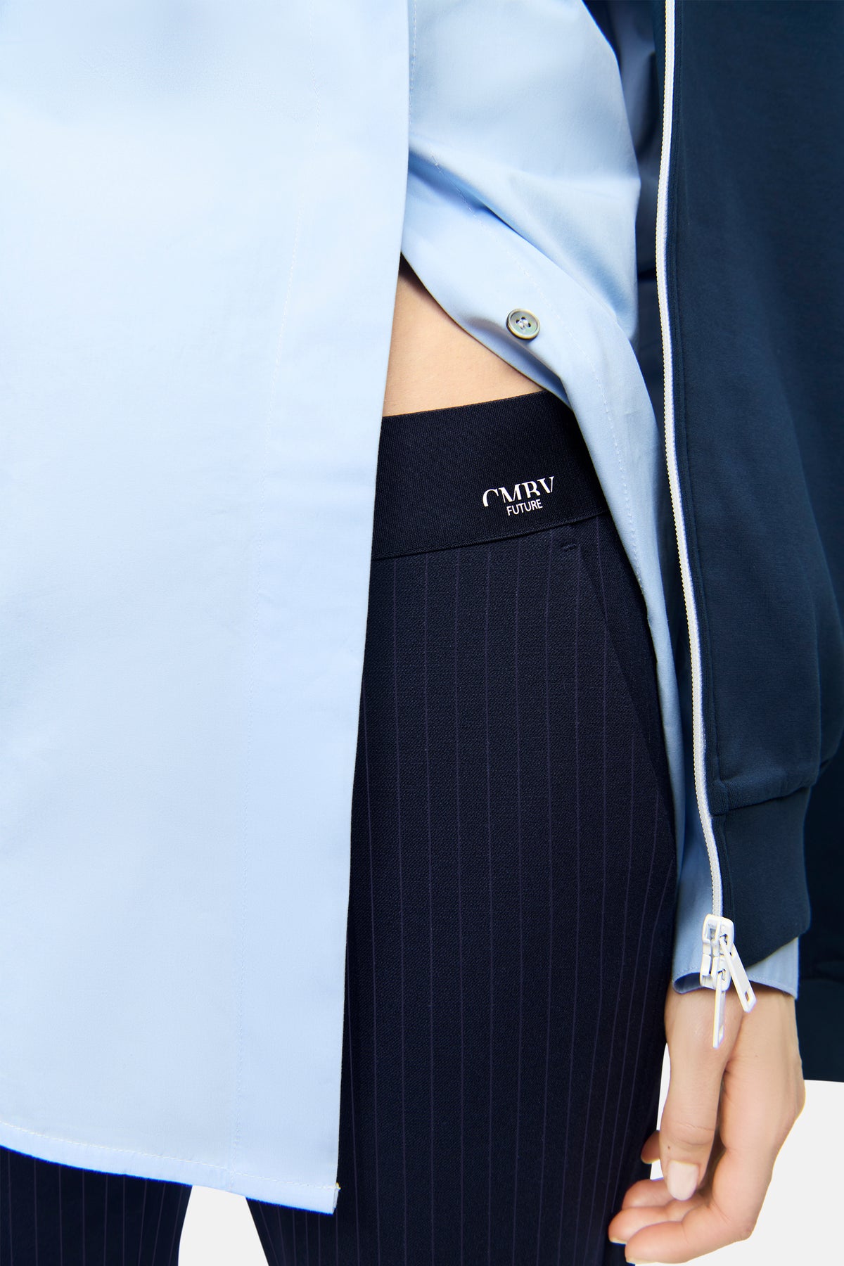 Dunkelblaue Nadelstreifen-Hose aus 62% Polyester, 26% Viskose, 9% Wolle, 3% Elasthan; im urbanen Setting getragen.