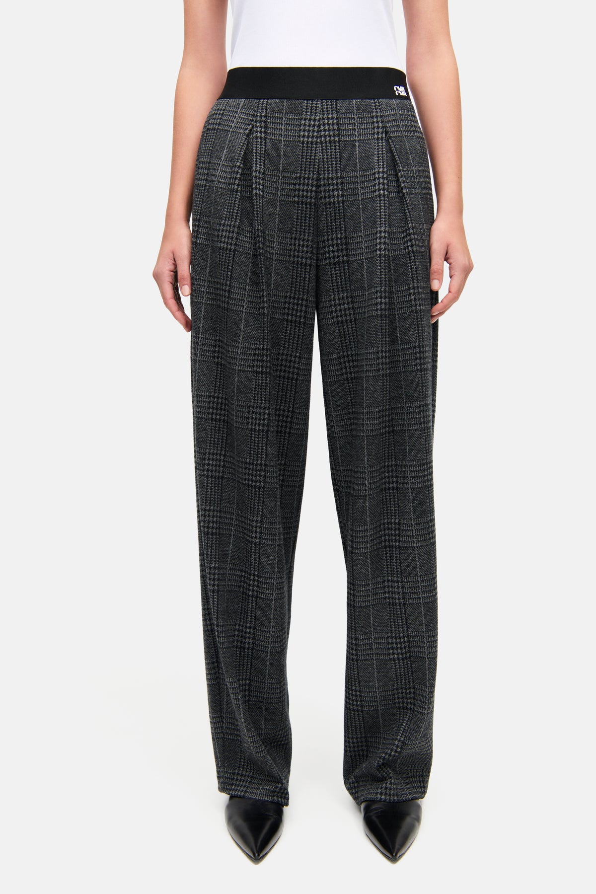 Graue O-Shape-Hose aus gebürstetem Glencheck-Jersey, bestehend aus Baumwolle, Viskose, Elastan und Polyester. Die Hose hat einen elastischen Bund.