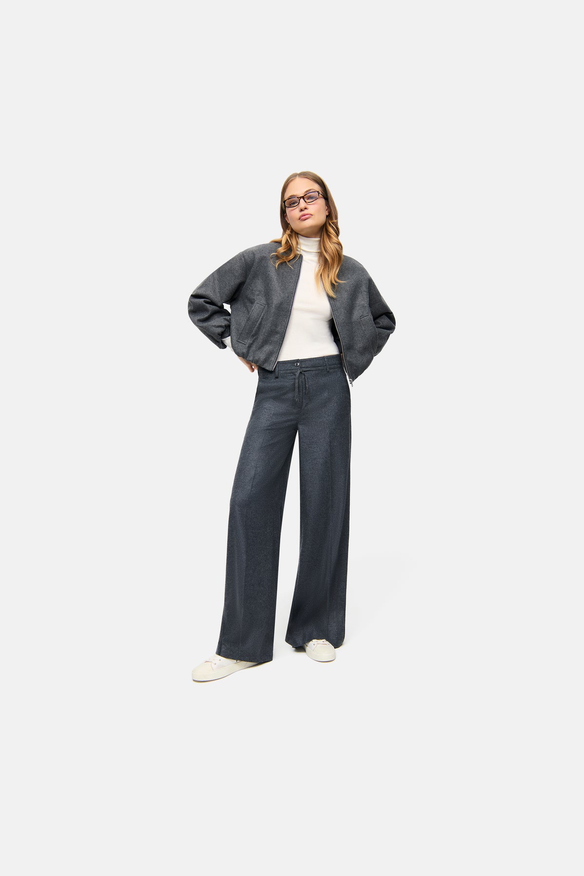Graue Wide Leg Hose aus Wool Flanell, getragen von einer Person in einer modernen Pose. Material: 55% Wolle, 45% Polyester.