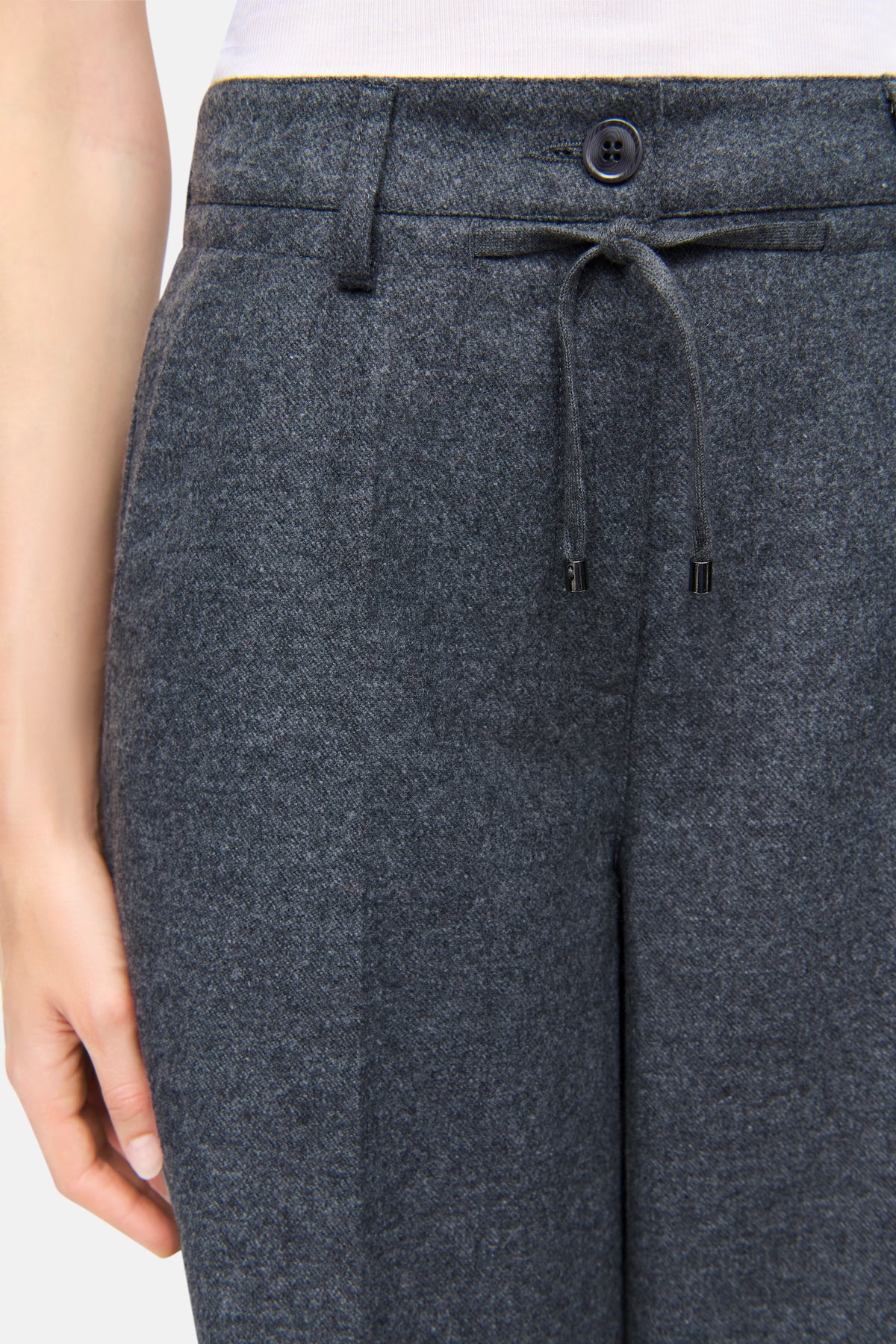 Graue Wollflanellhose mit weitem Bein, aus 55% Wolle und 45% Polyester, mit Knopfverschluss und Kordelzug, getragen von einer Person.