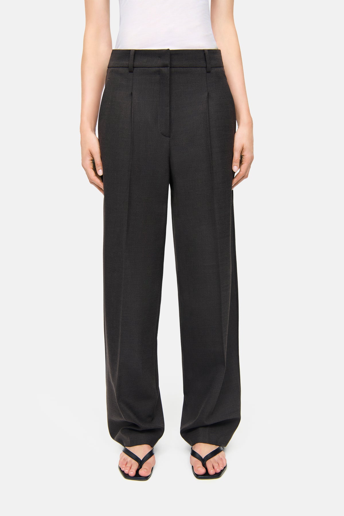 O-Shape Hose in Braun aus 53% Polyester, 43% Schurwolle, 4% Elasthan getragen von einer Person in einem neutralen Setting.