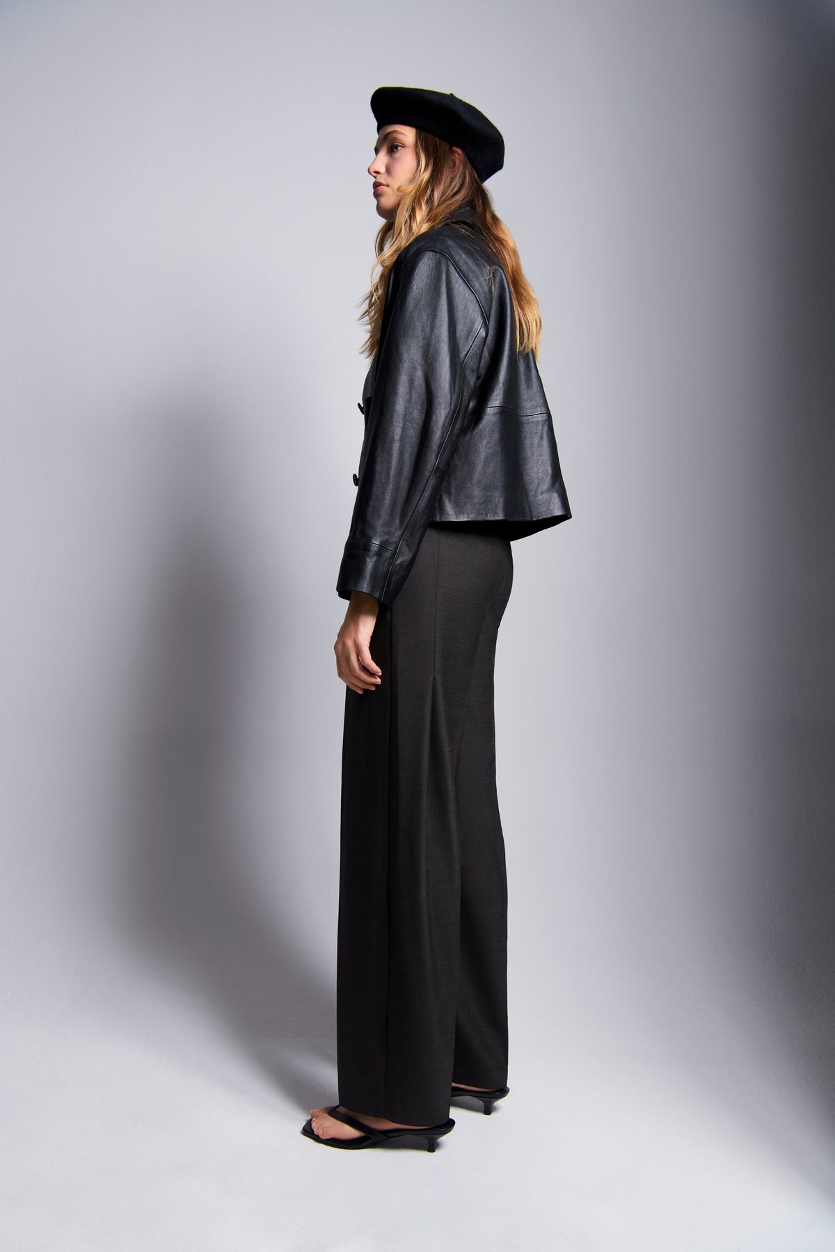 Braune O-Shape Hose aus 53% Polyester, 43% Schurwolle, 4% Elasthan. Modernes Outfit mit Lederjacke und schwarzem Barett.