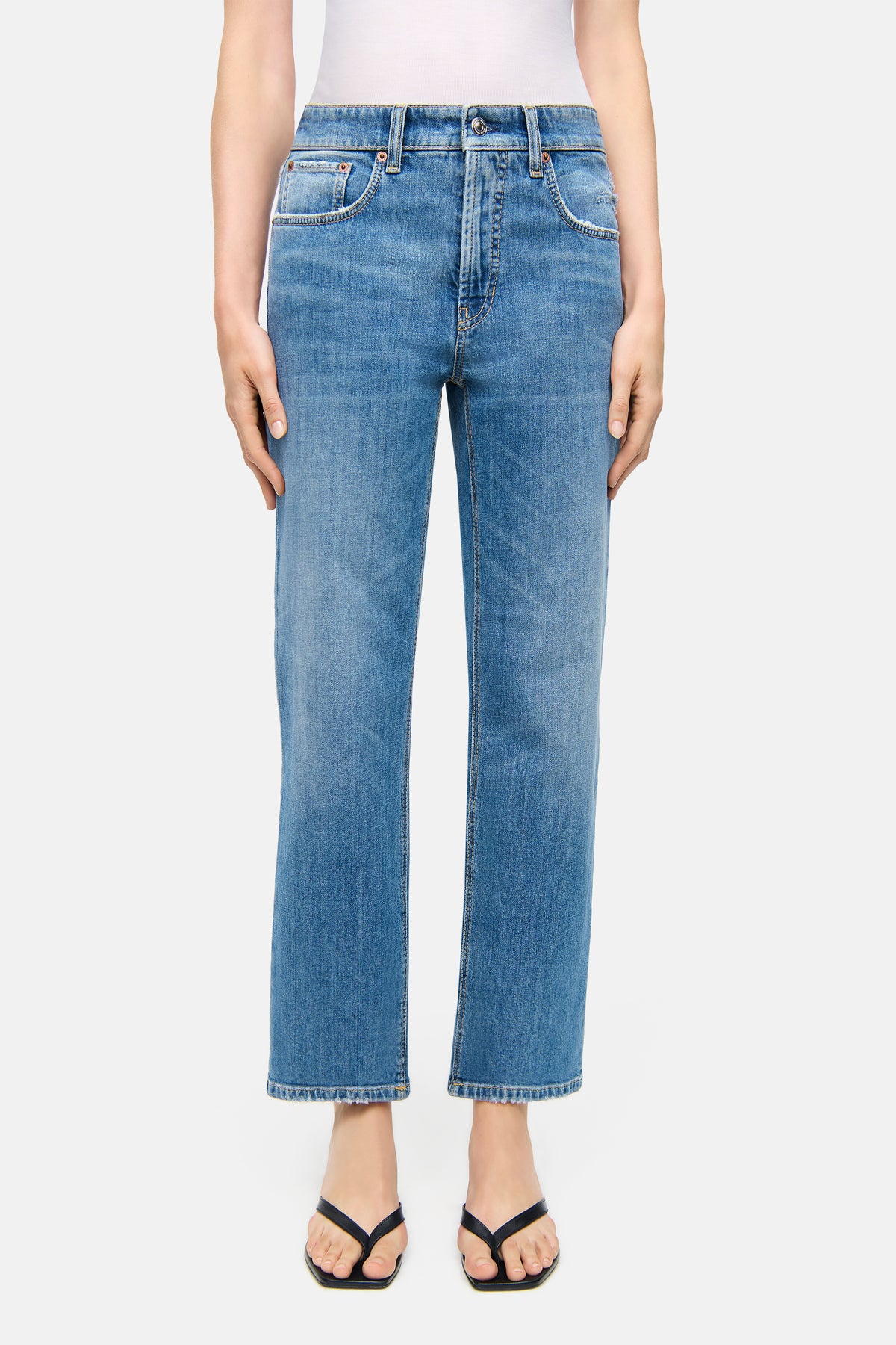 Blaue Straight-Fit Jeans aus 98% Baumwolle und 2% Elasthan, getragen in einem lässigen, urbanen Alltagsumfeld.