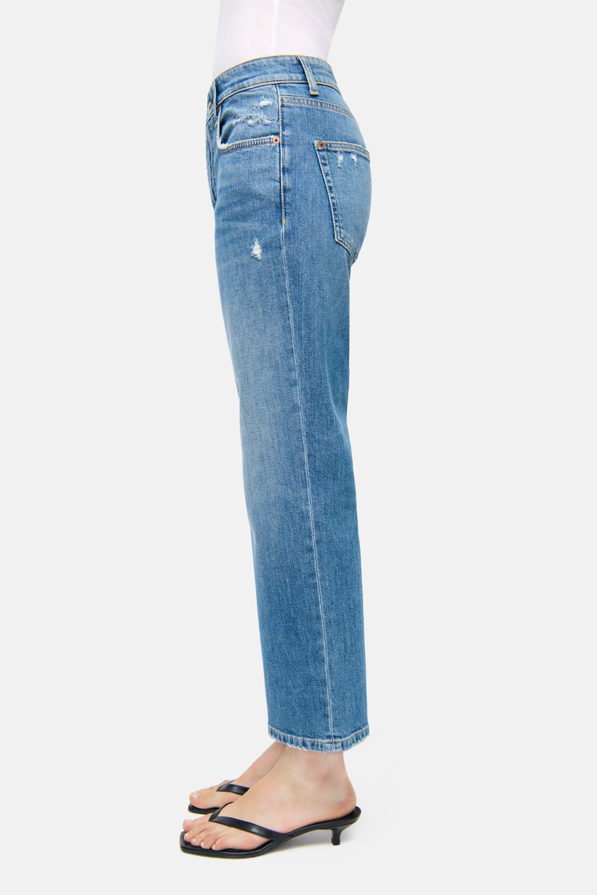 Blaue Straight-Fit Jeans aus 98% Baumwolle und 2% Elasthan, im 5-Pocket-Design, getragen von einer Person in Sandalen.