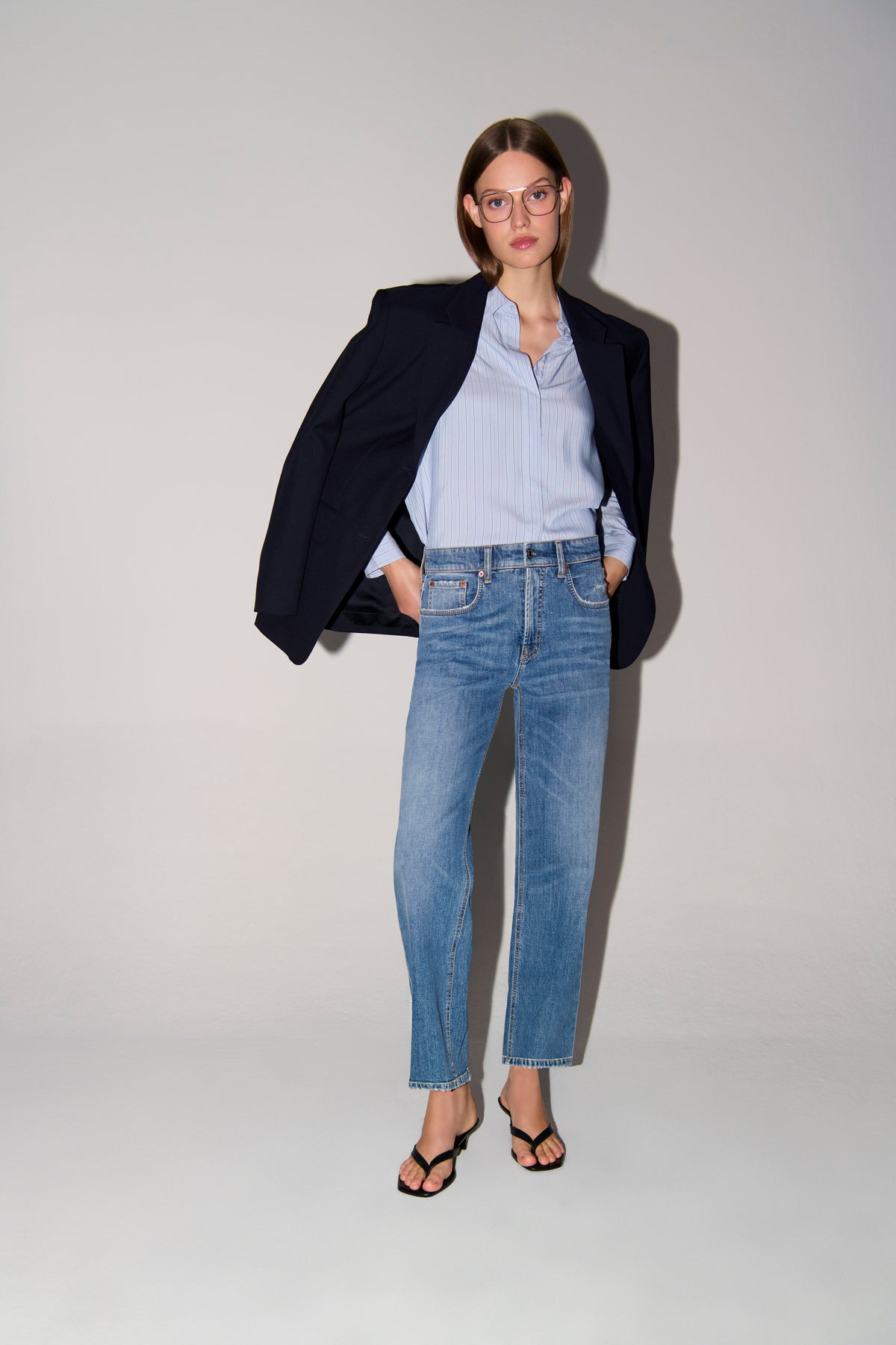 Frau in heller, gerader Jeans aus 98% Baumwolle und 2% Elasthan, mit leichter Used-Optik und klassischem 5-Pocket-Design.