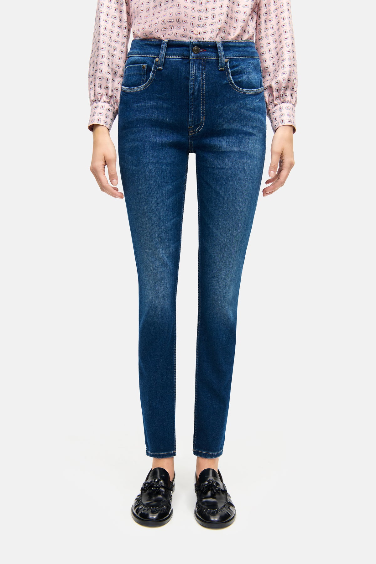 Blaue Skinny-Fit Jeans aus 81% Baumwolle, 11% Lyocell, 6% Elastomultiester T400 und 2% Elasthan, getragen von einer Person.