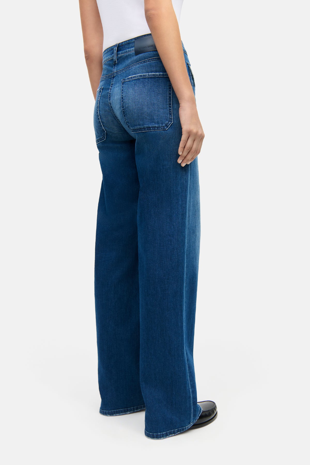 Dunkelblaue Wide-Fit-Jeans aus 94% Baumwolle, 4% Elastomultiester T400, 2% Elasthan. Getragen von einer Person in neutraler Umgebung.