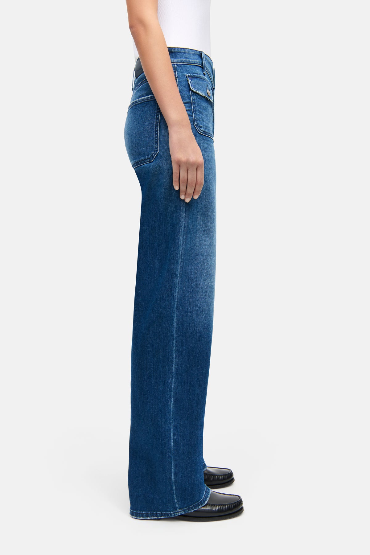 Blaue Wide-Leg-Jeans "Aimee Patched Pocket" mit aufgesetzten Vordertaschen. Material: 94% Baumwolle, 4% Elastomultiester, 2% Elasthan. Seitliche Ansicht zeigt Hose an Person in neutralem Kontext.