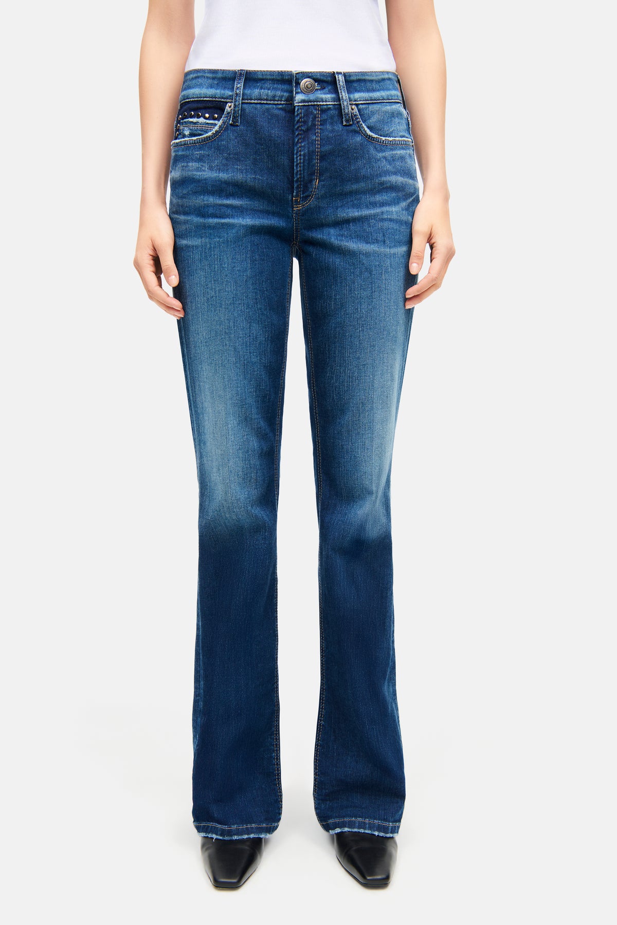 Blaue Flared-Fit Jeans aus 92 % Baumwolle, 6 % Elastomultiester, 2 % Elasthan, getragen von einer Person.