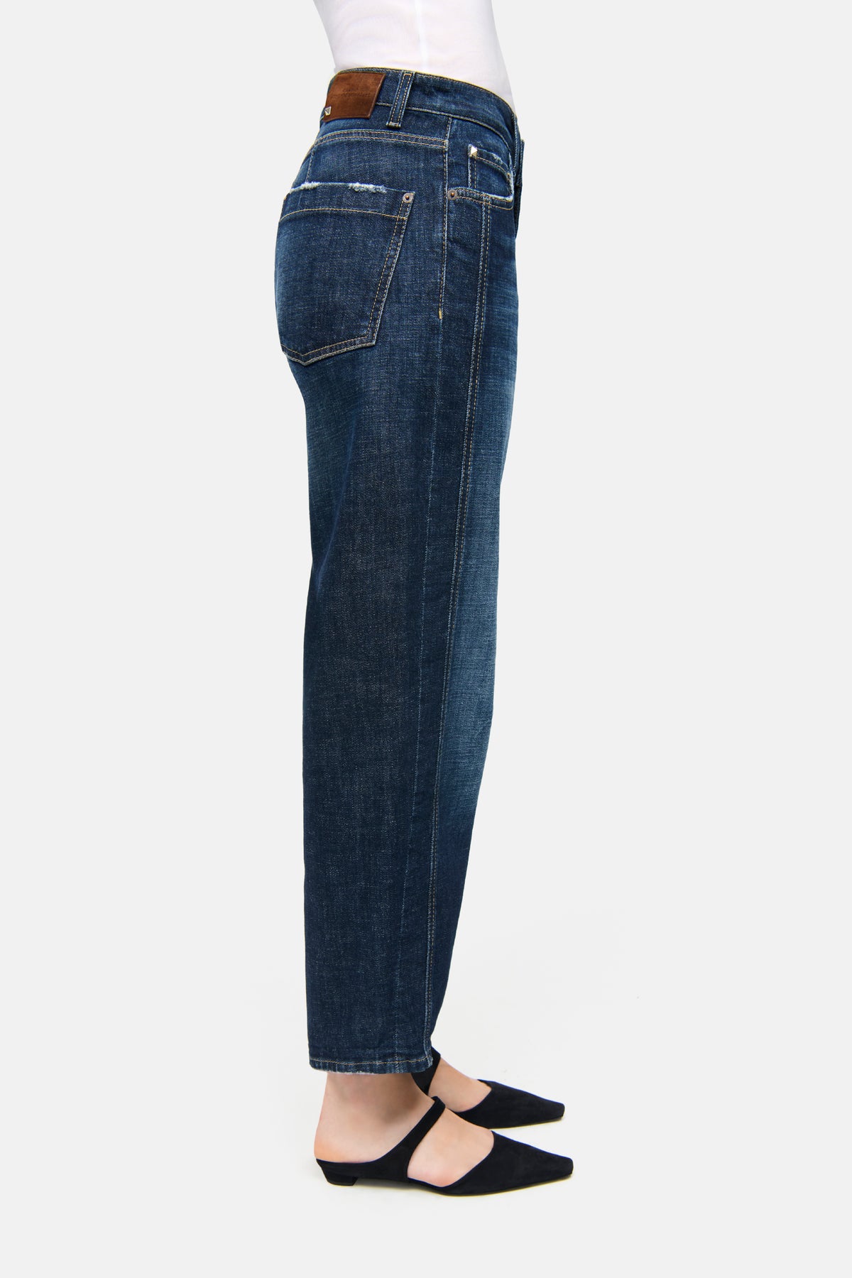 Dunkelblaue O-Shape-Jeans aus 98% Baumwolle und 2% Elasthan, getragen mit schwarzen Schuhen auf weißem Hintergrund.