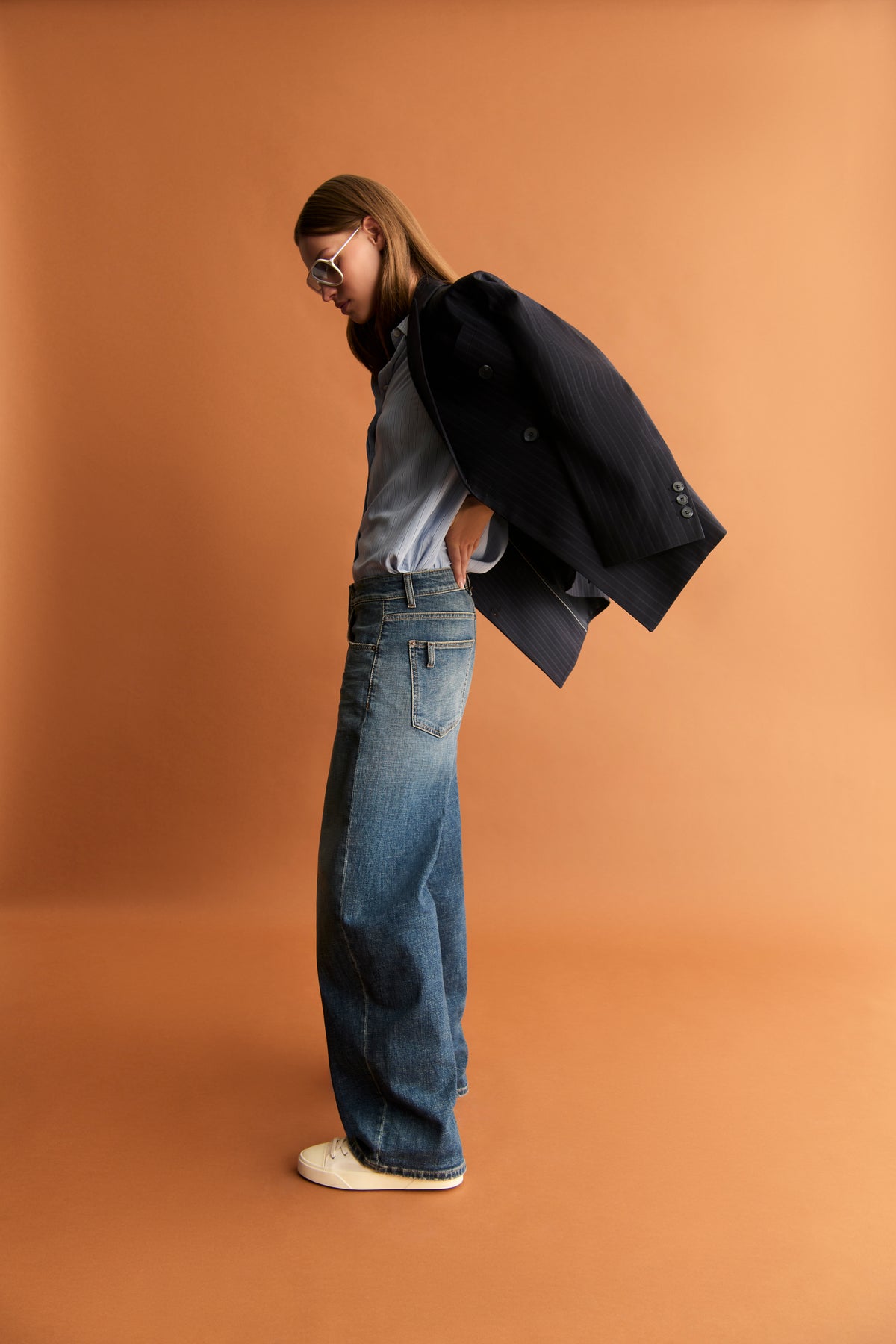 Weite Jeanshose in klassischem Denim, Baggy-Fit, 98% Baumwolle, 2% Elasthan, Person im Profil in urbaner Kulisse.