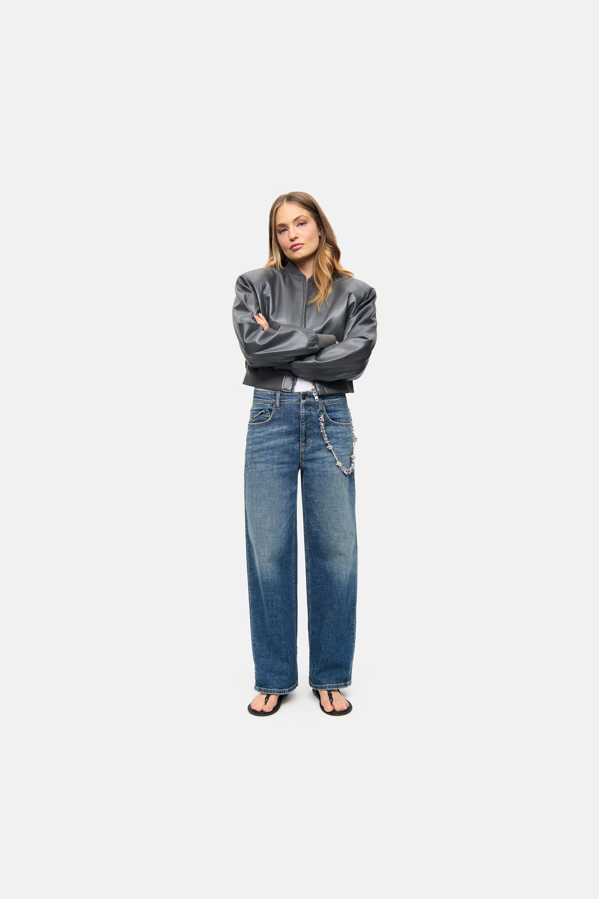 Damen trägt eine weite Baggy-Jeans mit Strasskette, aus 98% Baumwolle und 2% Elasthan, in einem urbanen Setting.