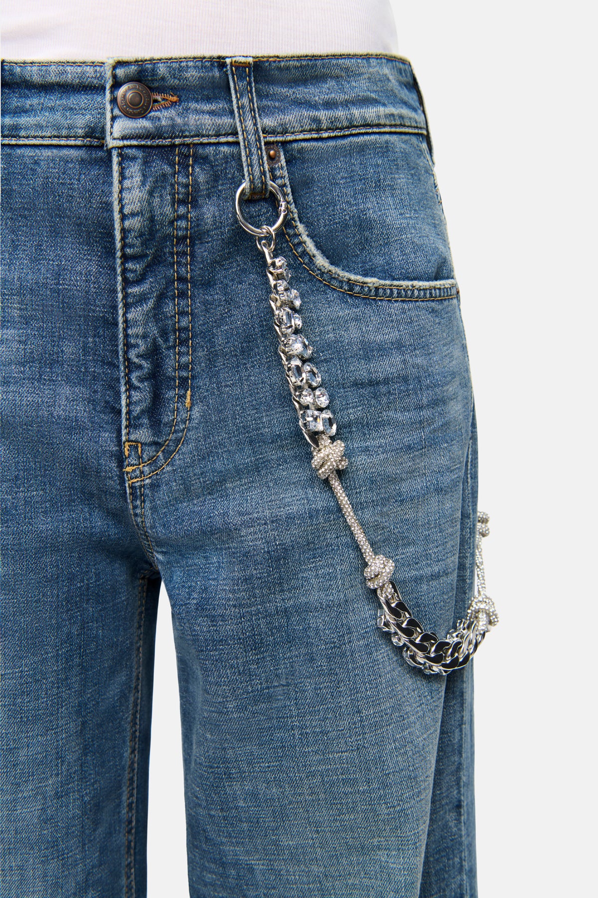Blaue Baggy-Jeans aus 98% Baumwolle und 2% Elasthan mit Five-Pocket-Design. Strasskette als Detail an der Hüfte sichtbar.