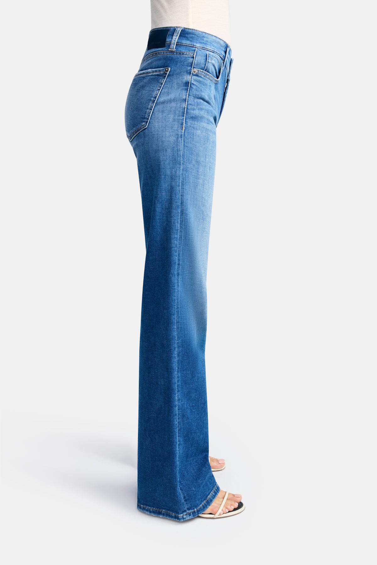 Blaue Wide Leg Jeans mit weitem Bein und 5-Pocket-Design, aus 92% Baumwolle, 6% Elastomultiester T400, 2% Elasthan. Seitliche Ansicht einer stehenden Person.
