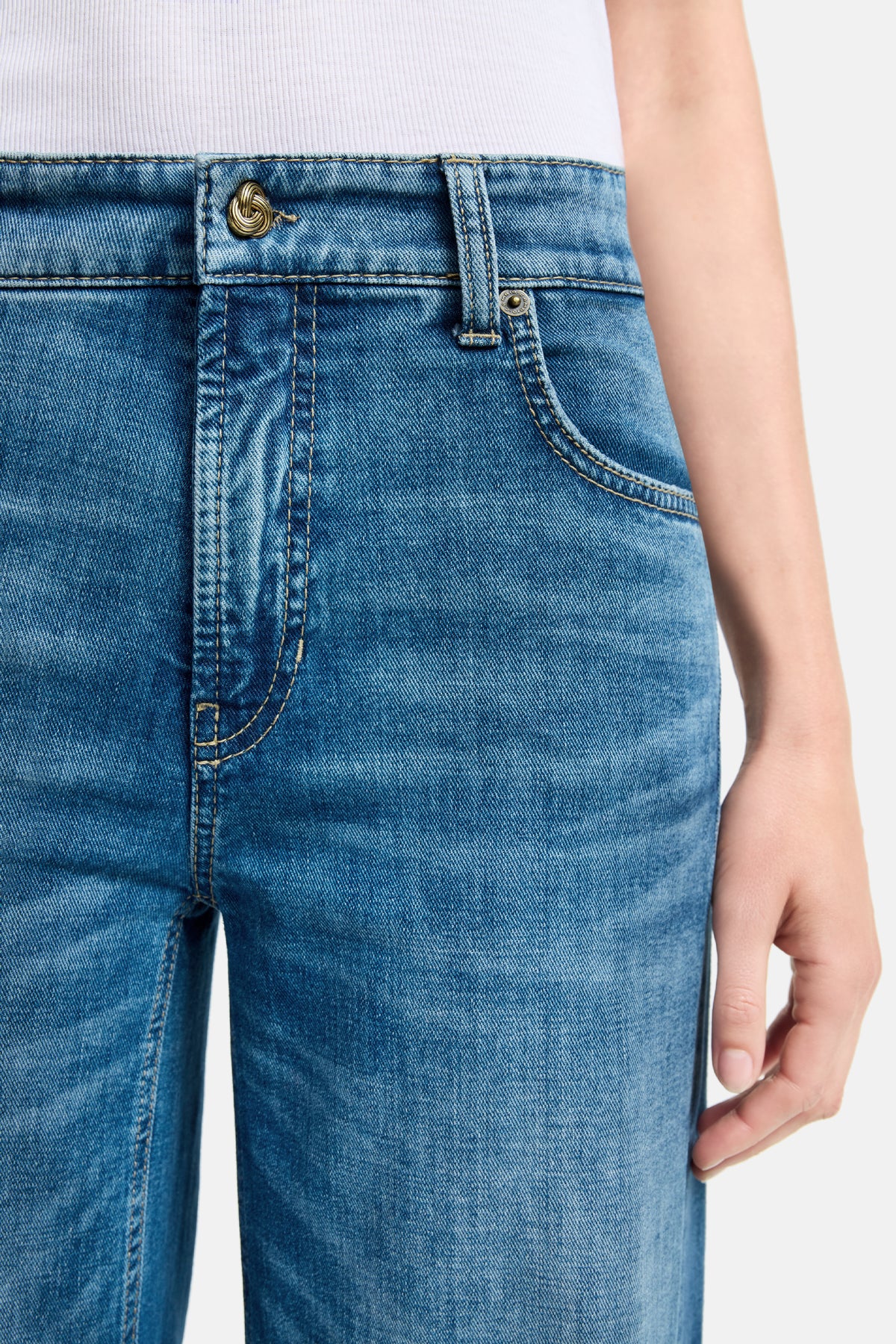 Damen trägt eine hellblaue Palazzo-Jeans aus 92% Baumwolle, 6% Elastomultiester, 2% Elasthan in urbanem Umfeld.