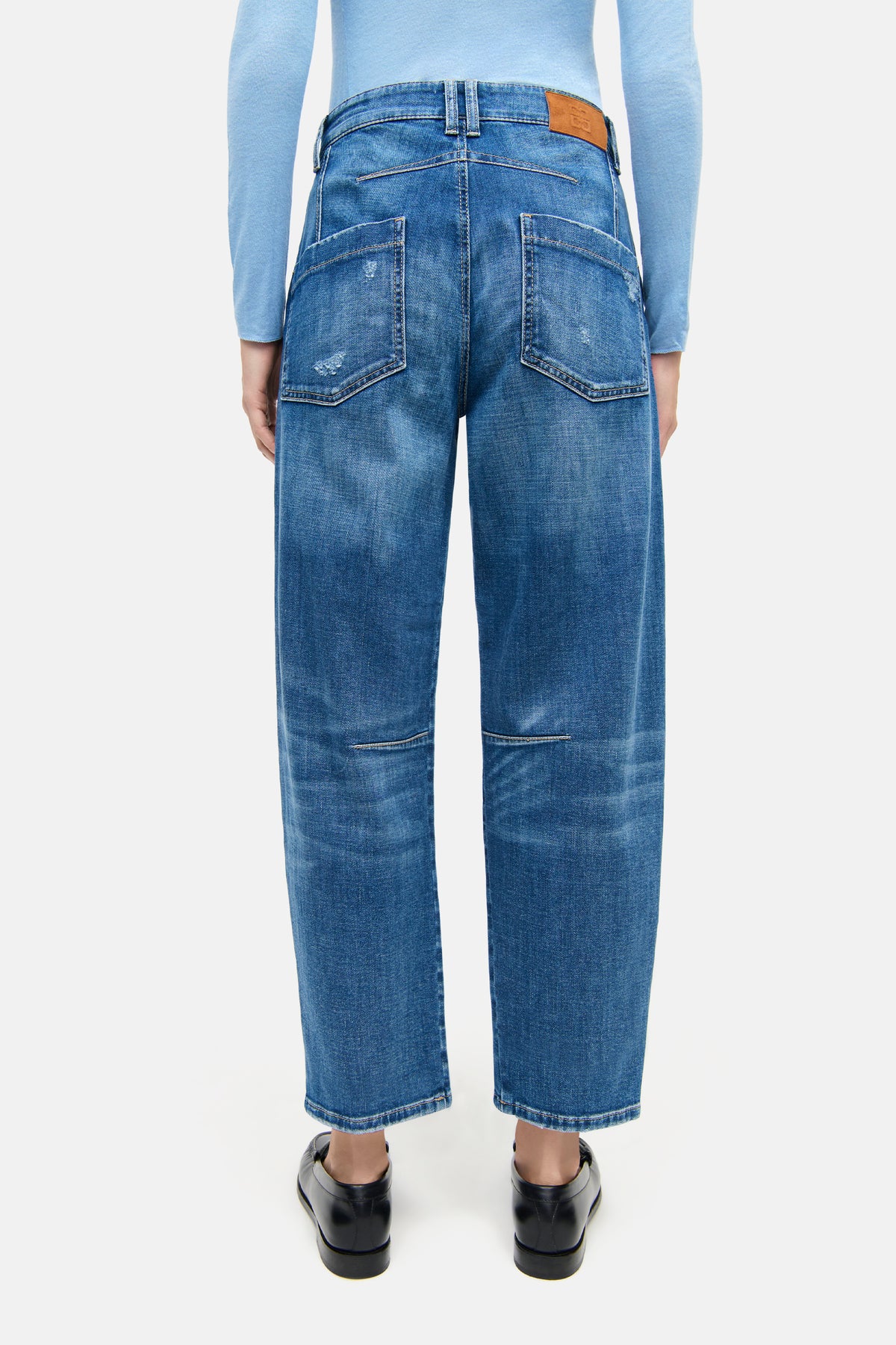 Blaue Jeans in O-Shape aus 92% Baumwolle, 6% Elastomultiester T400, 2% Elasthan. Person in casual Outfit von hinten.