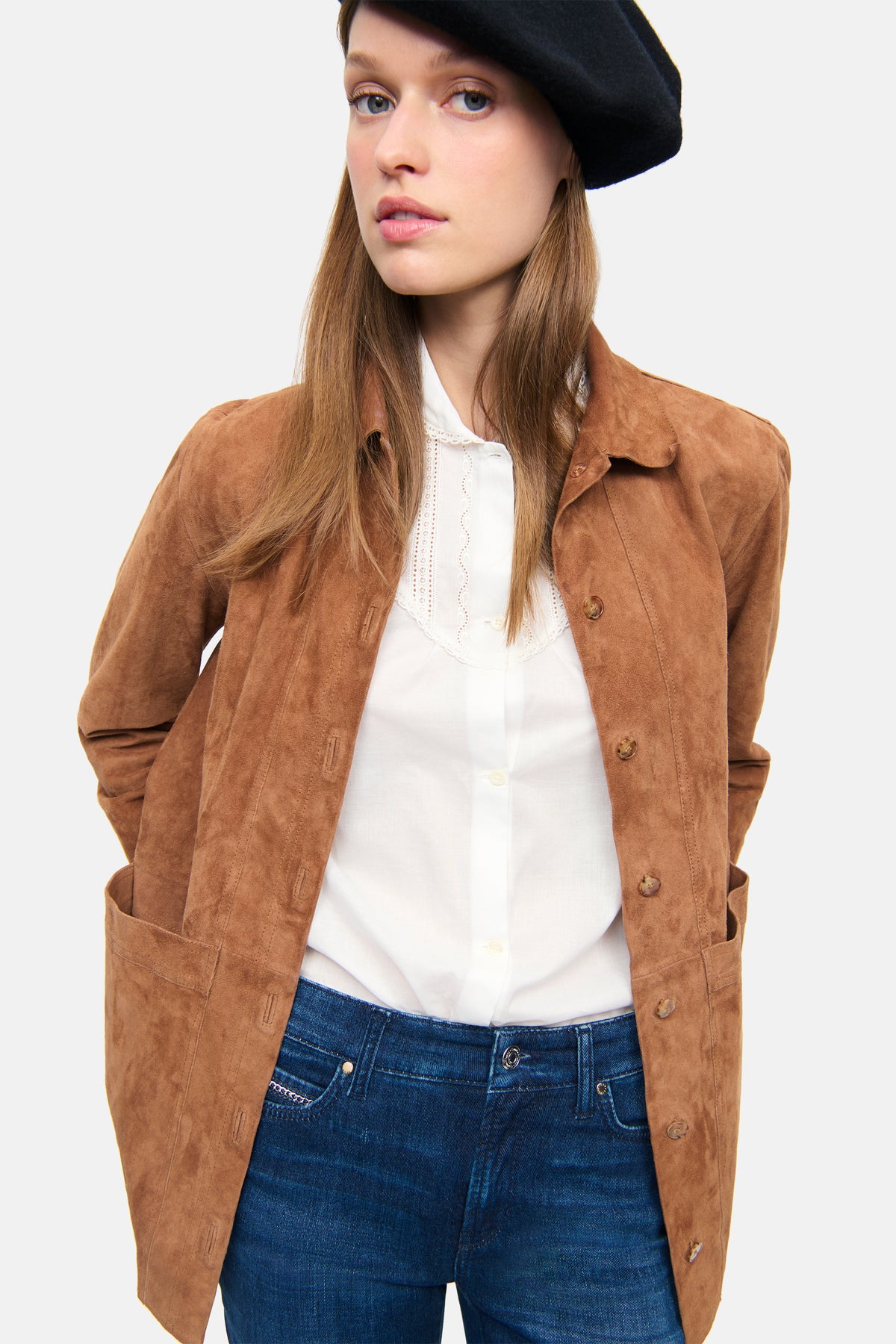 Frau in urbanem Setting trägt blaue, ausgestellte Denim-Hose aus 92% Baumwolle, 6% Elastomultiester, 2% Elasthan.