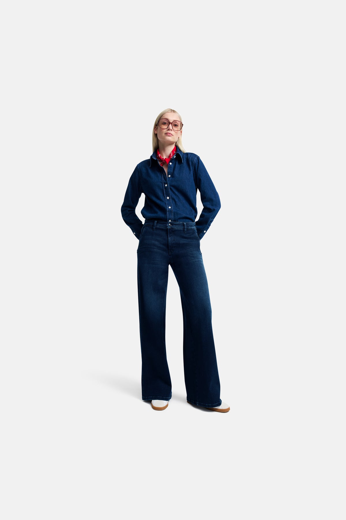 Blaue Wide-Leg-Jeans aus 93% Baumwolle, 5% Polyester, 2% Elasthan. Frau trägt sie in entspanntem, modernem Stil.