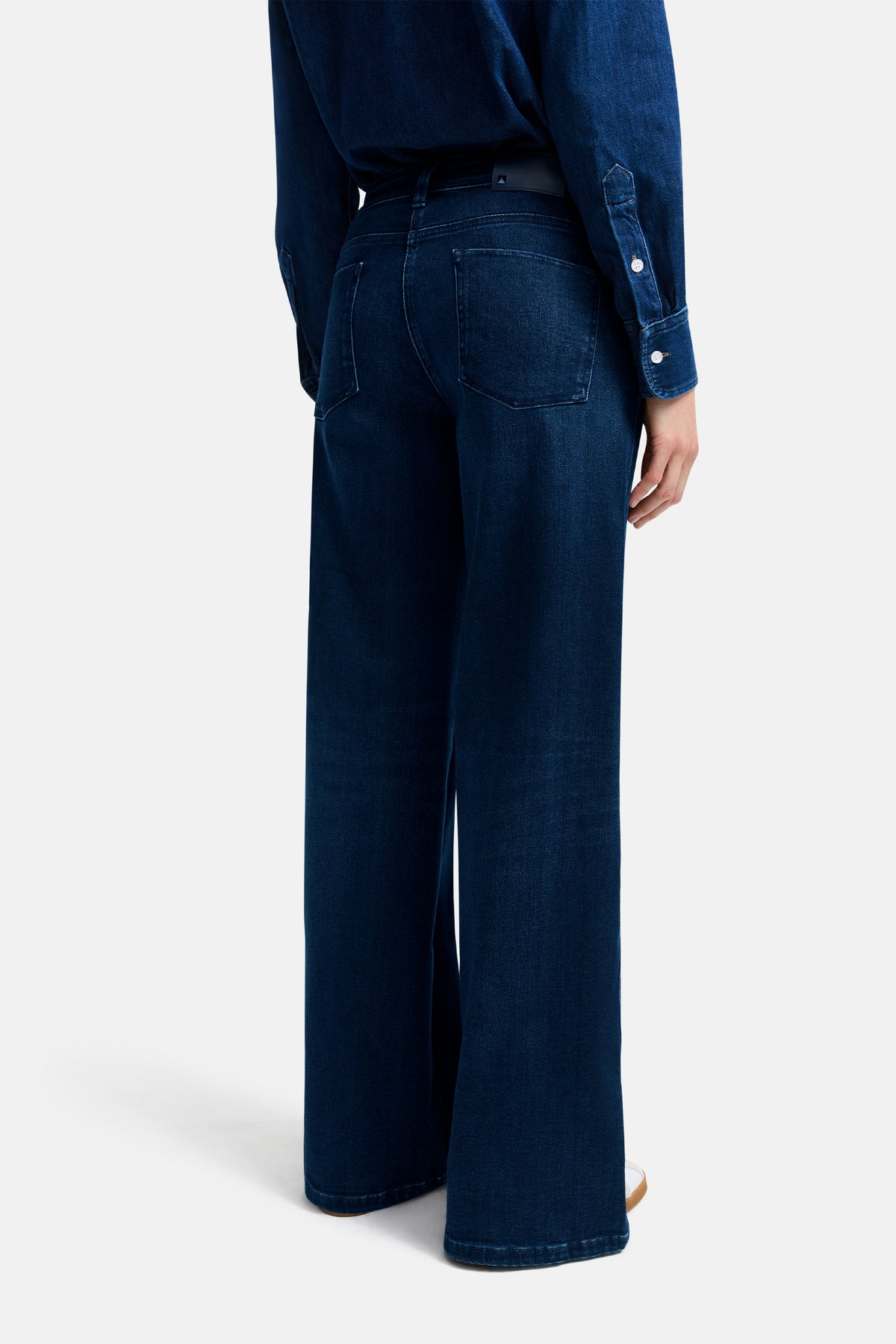 Dunkelblaue Wide Leg Jeans mit weitem Schnitt, Voll-Länge, aus 93 % Baumwolle, 5 % Polyester, 2 % Elasthan. Getragen in einer entspannten Pose.