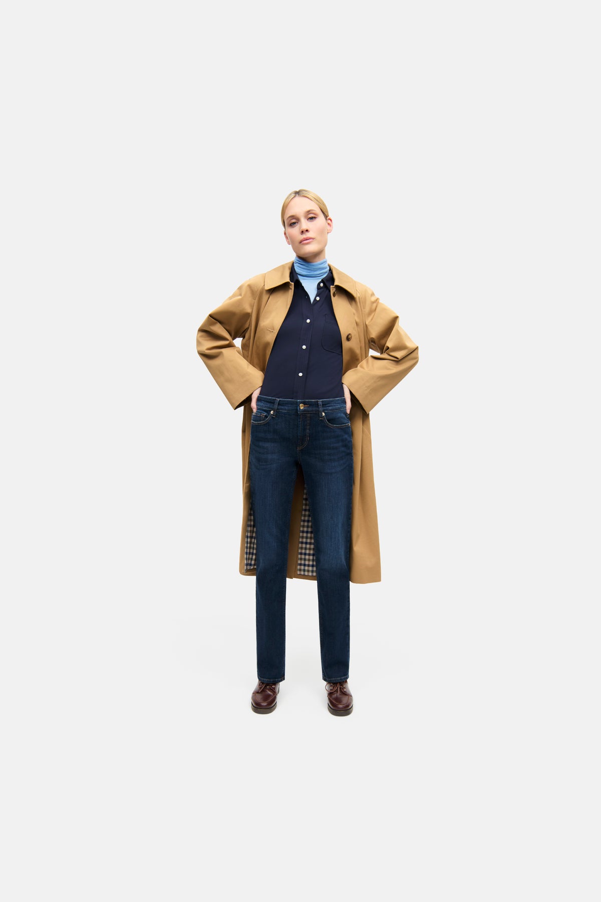 Dunkelblaue Slim-Fit-Jeans aus 93% Baumwolle, 5% Polyester, 2% Elasthan in urbanem Setting, getragen von einer Person im Mantel.