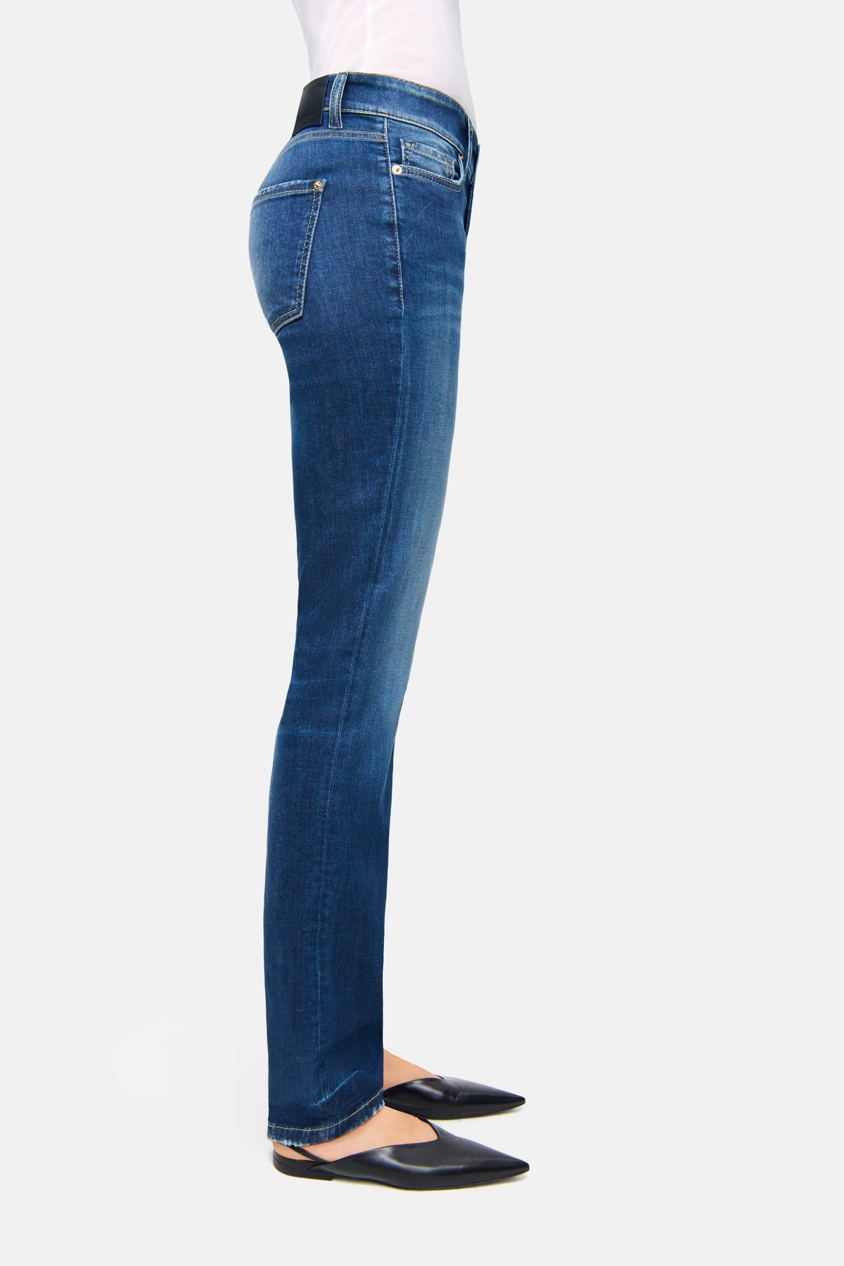Dunkelblaue Slim-Fit-Denim-Hose aus 92 % Baumwolle, 6 % Elastomultiester T400, 2 % Elasthan. Person steht auf weißen Boden.