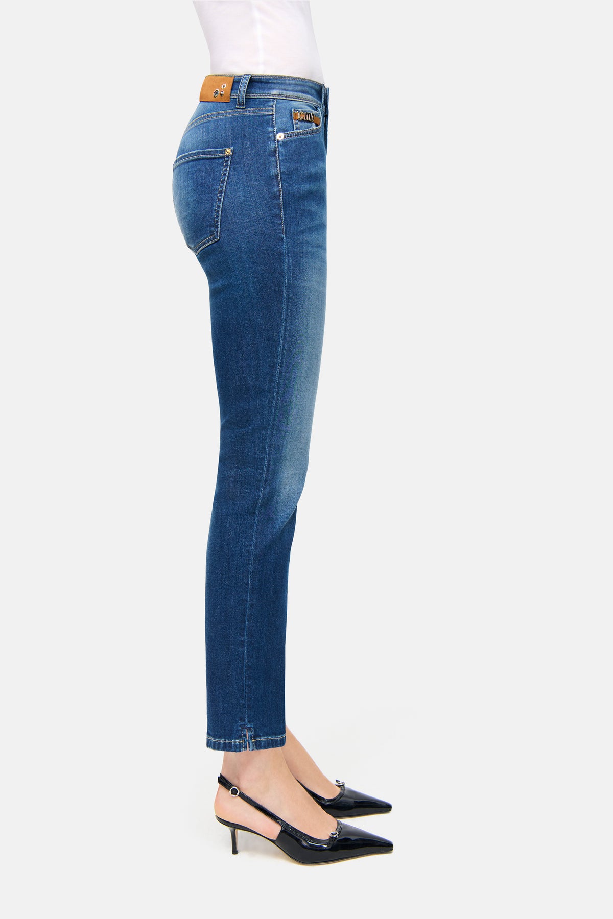 Blaue Slim-Fit-Jeans in verkürzter Länge aus 92% Baumwolle, 6% Elastomultiester T400, 2% Elasthan. Seitliche Ansicht, getragen mit High Heels.