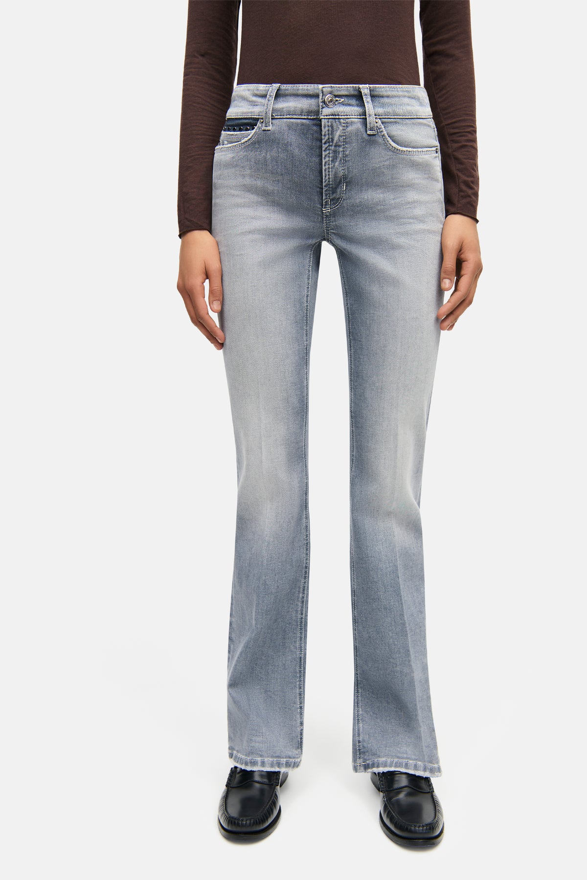 Graue Flared-Fit-Jeans aus 92% Baumwolle, 6% Elastomultiester T400, 2% Elasthan, getragen von einer Person in Alltagskleidung.