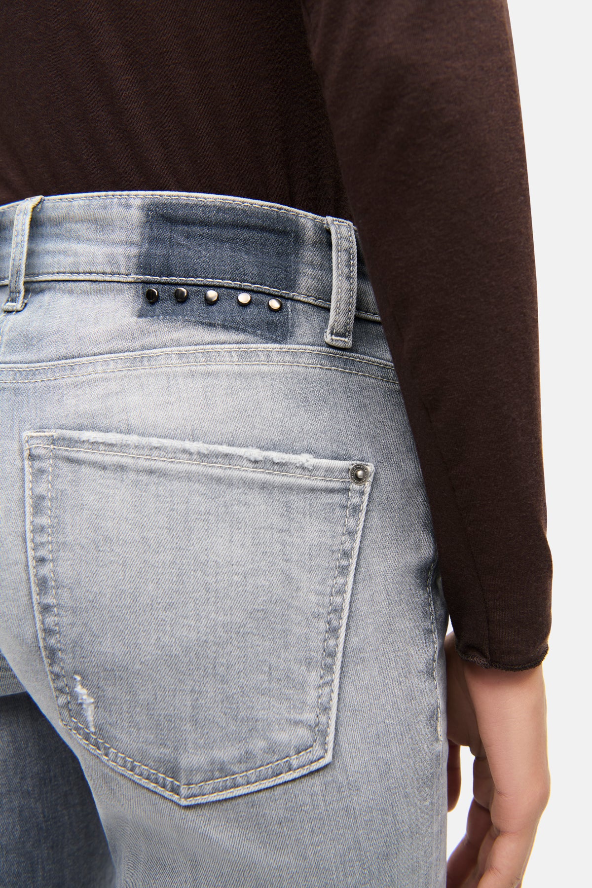 Graue Flared Jeans aus 92% Baumwolle, 6% Elastomultiester T400, 2% Elasthan. Getragen in einem urbanen Setting.