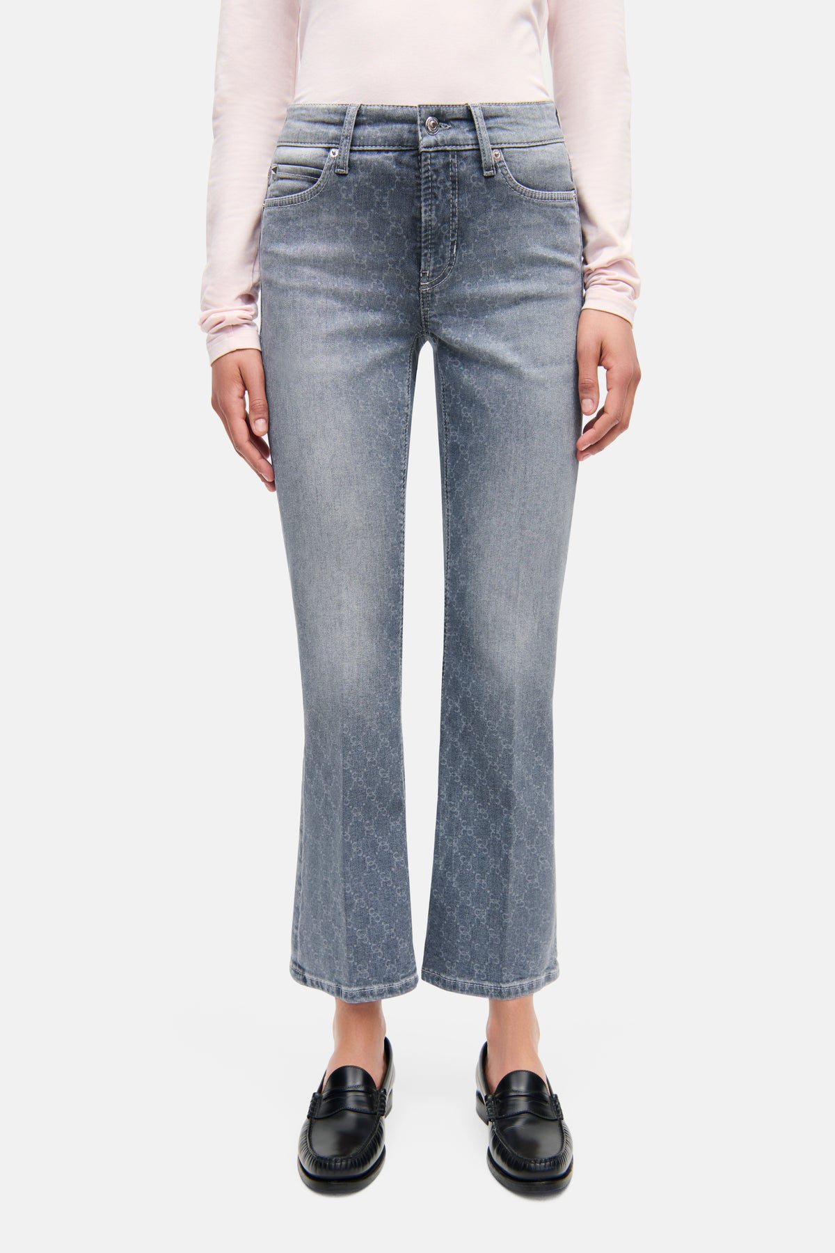 Hellgraue Flared-Fit-Cropped-Jeans aus Denim mit gelasertem Muster, getragen in urbanem Umfeld; 92% Baumwolle.