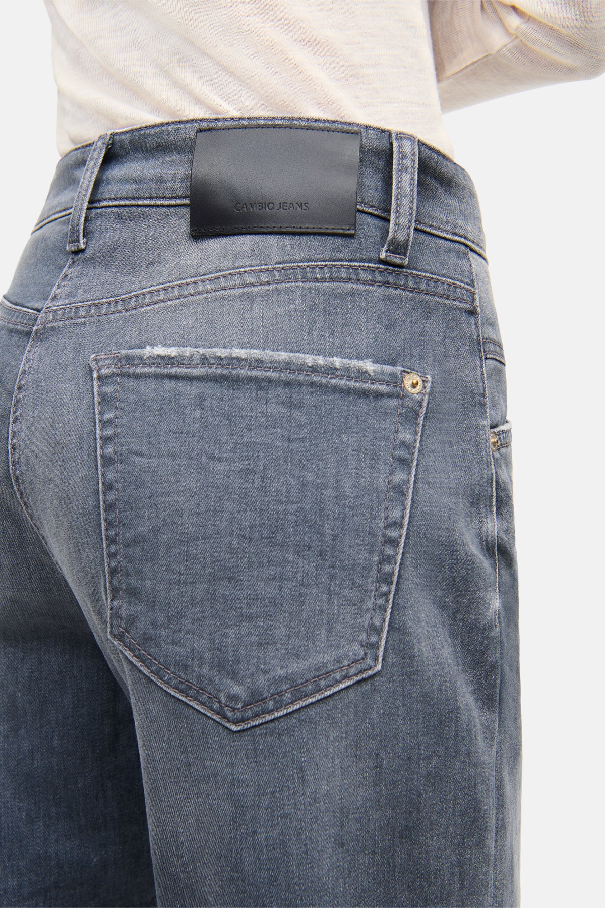 Graue Jeans im O-Shape aus 92% Baumwolle, 6% Elastomultiester T400 und 2% Elasthan. Person steht lässig mit Hände in Hosentaschen.