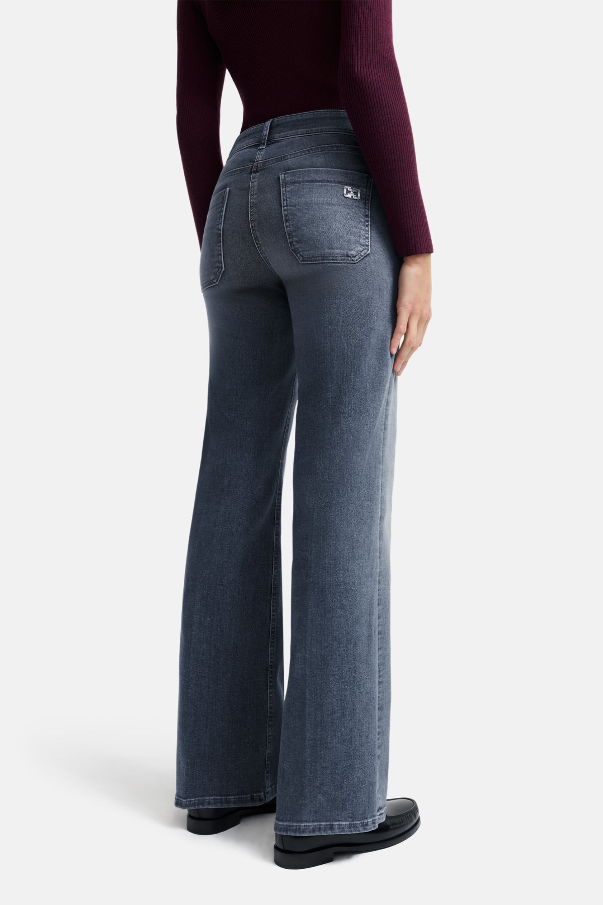 Graue Wide-Leg-Jeans aus 92% Baumwolle, 6% Elastomultiester T400, 2% Elasthan. Wird von einer Person in Alltagskleidung getragen.