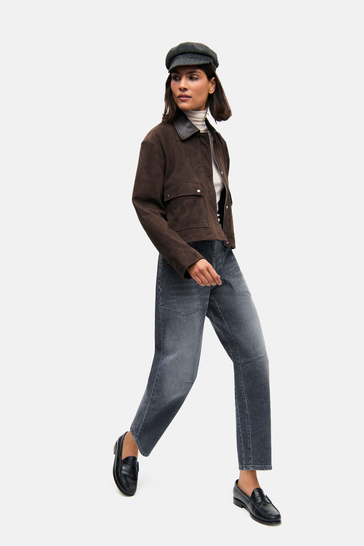 Blaue Jeans in O-Shape und verkürzter Länge aus 98% Baumwolle und 2% Elasthan. Getragen in urbanem Setting mit Jacke und Mütze.