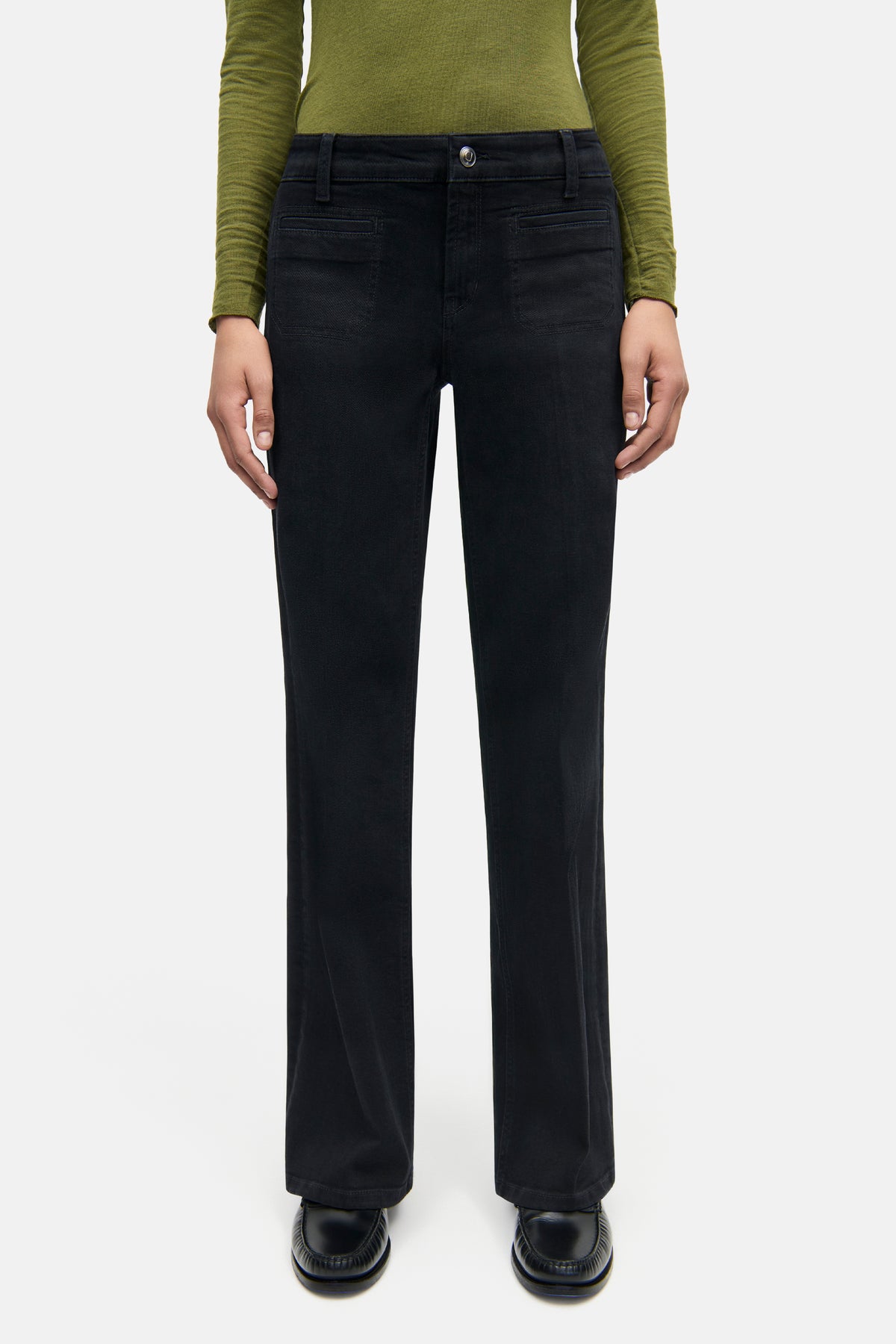 Schwarze Wide-Leg-Jeans aus 92% Baumwolle, 6% Elastomultiester T400, 2% Elasthan. Getragen von einer Person in grünem Oberteil.