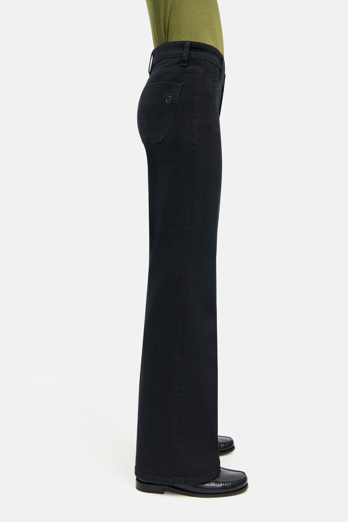 Schwarze Wide-Leg-Denim-Hose aus 92% Baumwolle, 6% Elastomultiester T400 und 2% Elasthan, getragen in einem Studio.