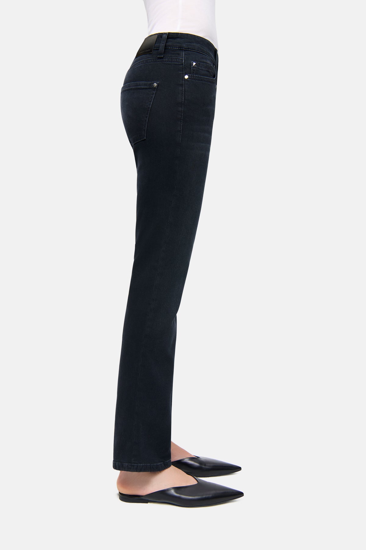 Schwarze Slim-Fit Damenhose aus Superstretch-Material, bestehend aus 57% Baumwolle, 37% Modal, 4% Elastomultiester T400, 2% Elasthan. Seitliche Ansicht getragen von einer Person im Profil.