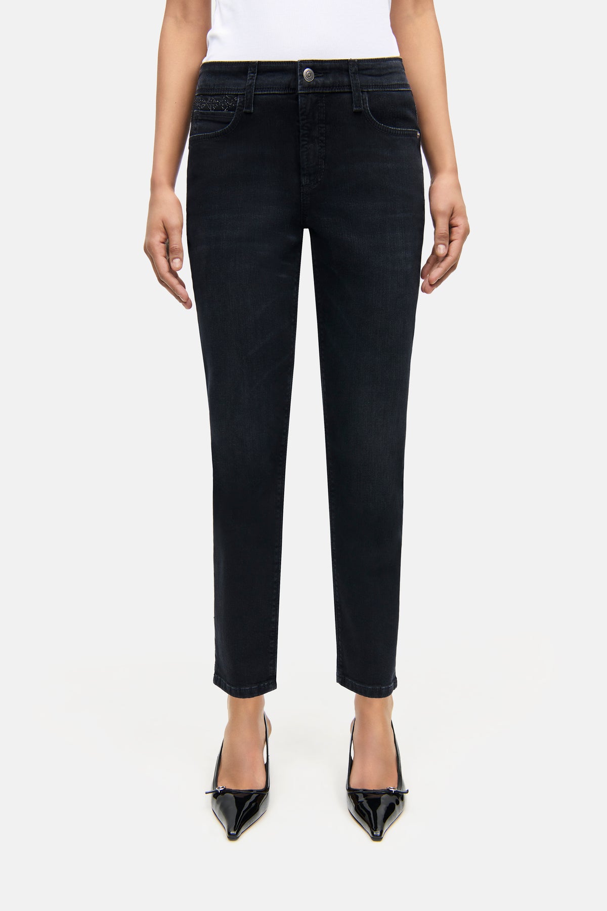 Schwarze Slim-Fit Jeans aus 57% Baumwolle und 37% Modal, 5-Pocket-Design, mit Strass-Details an der Vordertasche. Getragen im Studio-Setting.