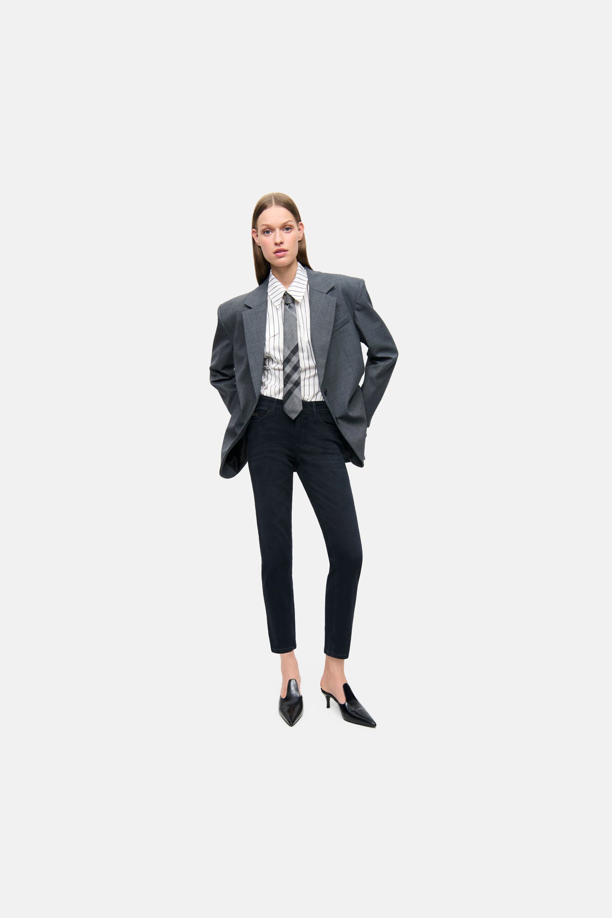 Schwarze Slim-Fit-Jeans "Piper short" aus 57% Baumwolle, 37% Modal, 4% Elastomultiester T400, 2% Elasthan, getragen in einem formellen Kontext mit Blazer und Hemd.